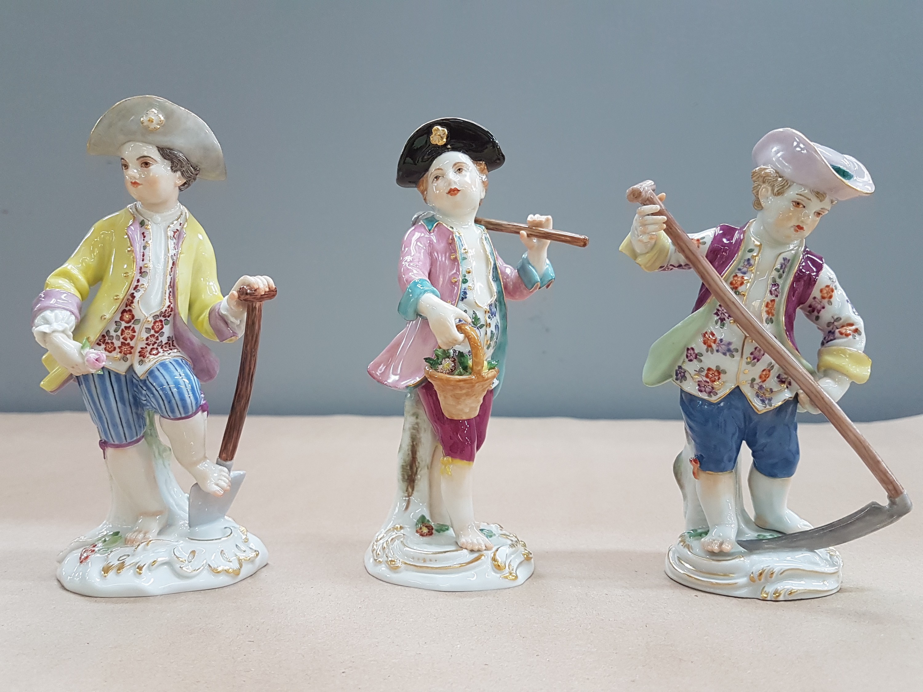 Detail a: 3 Porzellanfiguren, Meissen, 20. Jh., 1. Wahl, Gärtnerkinder mit Sense, Spaten und Harke, bunt bemalt, Goldstaffage, H. ca. 13-14cm