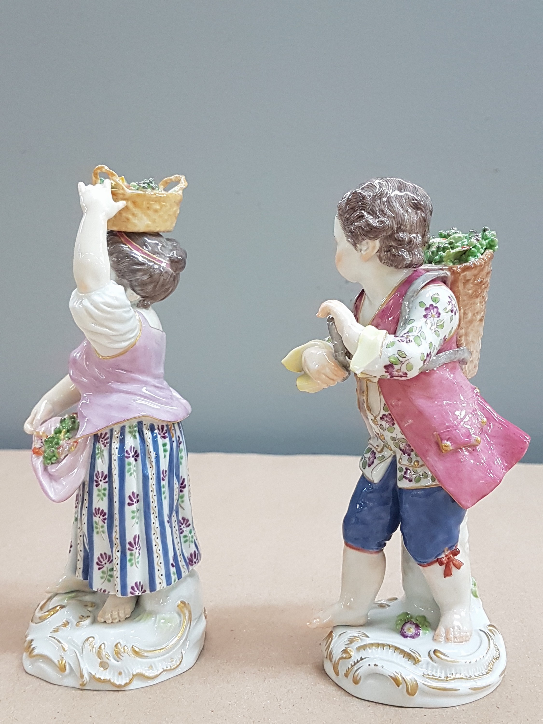 Detail b: 2 Porzellanfiguren, Meissen, 20. Jh., 1. Wahl, Winzerin mit Trauben im Korb auf dem Kopf und Winzer mit Kiepe, H. ca. 13/14cm
