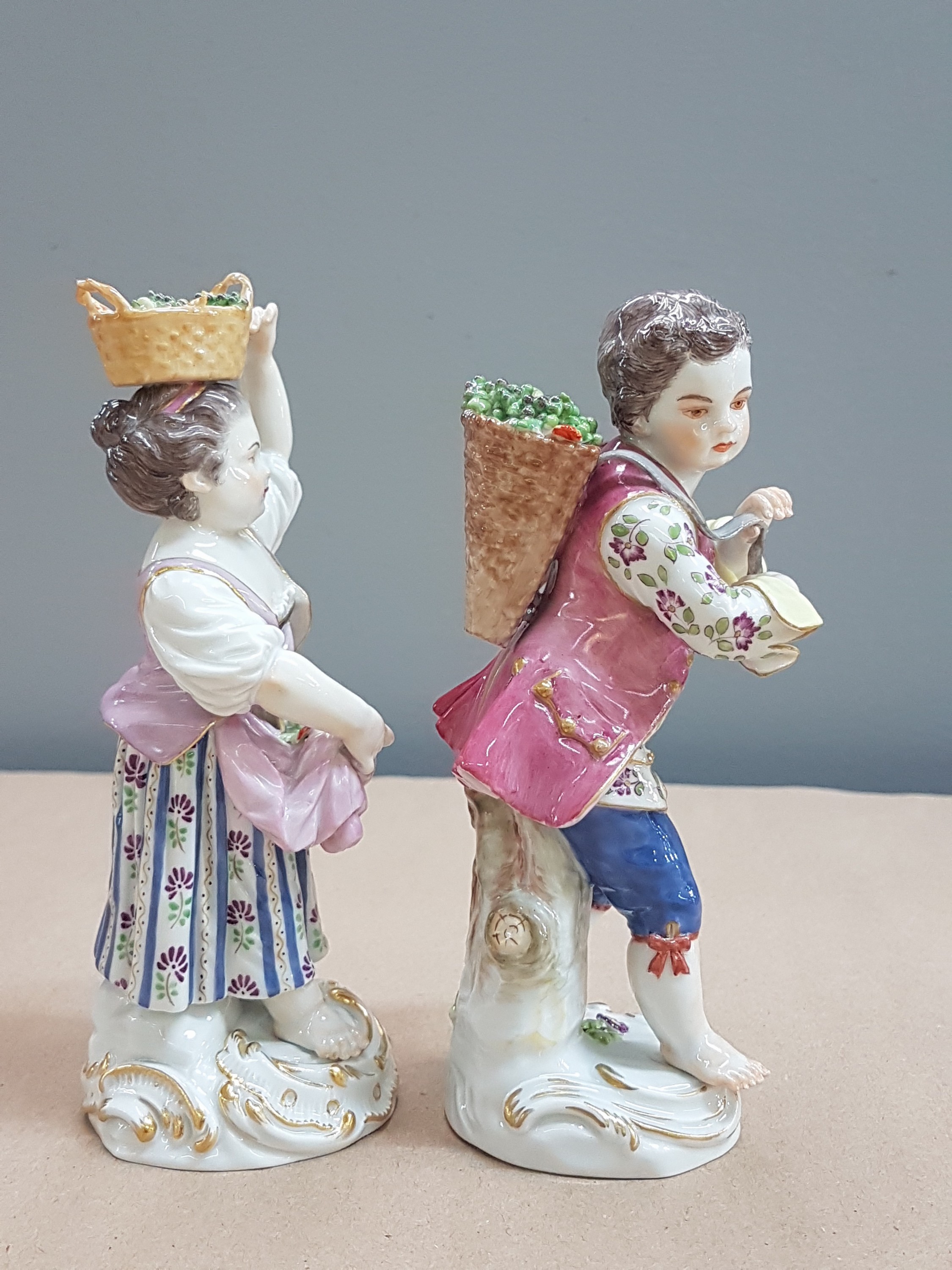 Detail d: 2 Porzellanfiguren, Meissen, 20. Jh., 1. Wahl, Winzerin mit Trauben im Korb auf dem Kopf und Winzer mit Kiepe, H. ca. 13/14cm