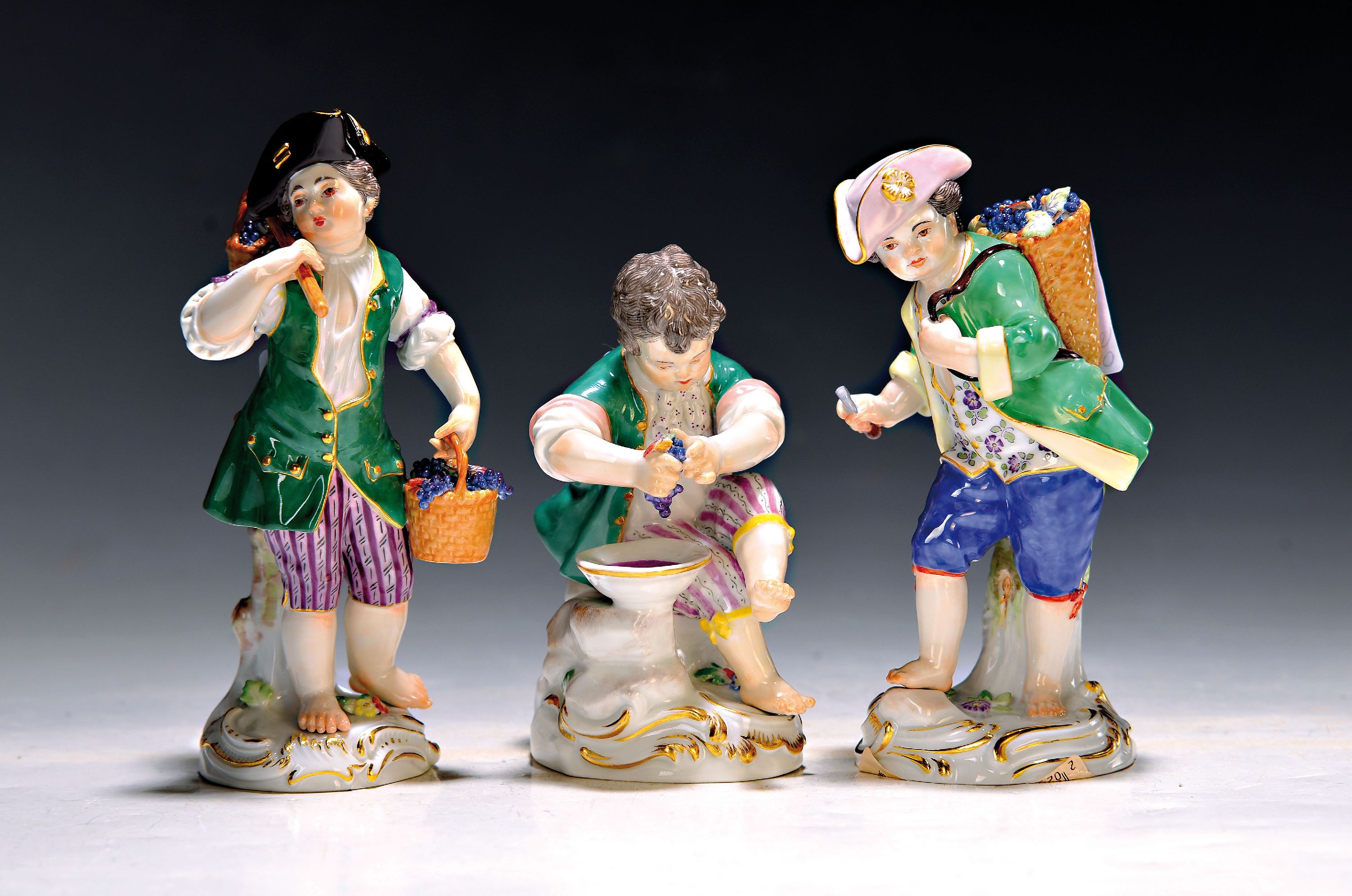 3 Porzellanfiguren, Meissen, 20. Jh., 1. Wahl, 3 Winzerknaben mit roten Trauben in Kiepe, Korb und beim Auspressen, H. ca. 11-14 cm