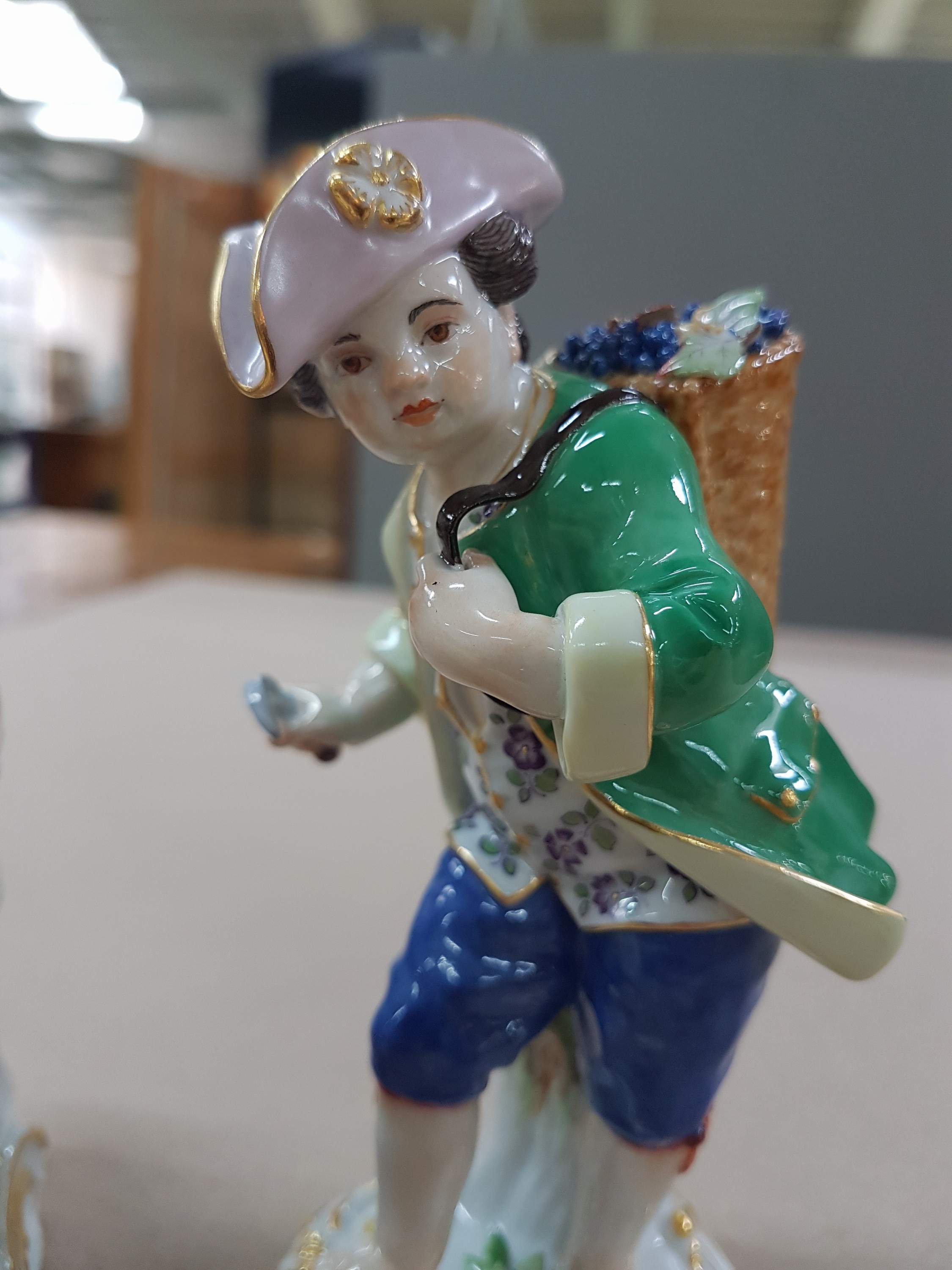 Detail j: 3 Porzellanfiguren, Meissen, 20. Jh., 1. Wahl, 3 Winzerknaben mit roten Trauben in Kiepe, Korb und beim Auspressen, H. ca. 11-14 cm