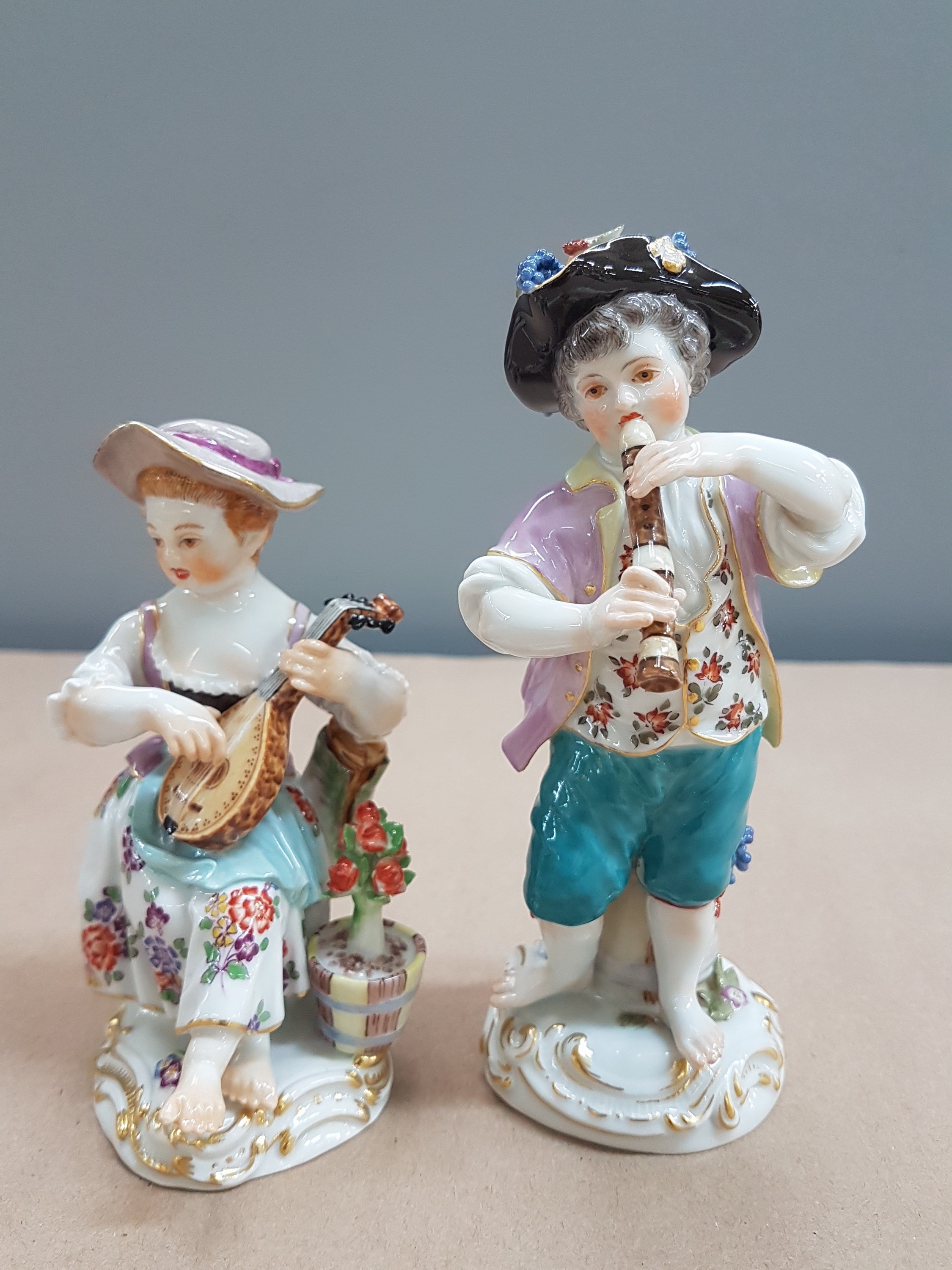 Detail a: 2 Porzellanfiguren, Meissen, 20. Jh., 1. Wahl, Mädchen mit Mandoline und Junge mit Flöte, bunt bemalt, Goldstaffage, H. ca. 11 bzw. 13.5cm, Hut des ...