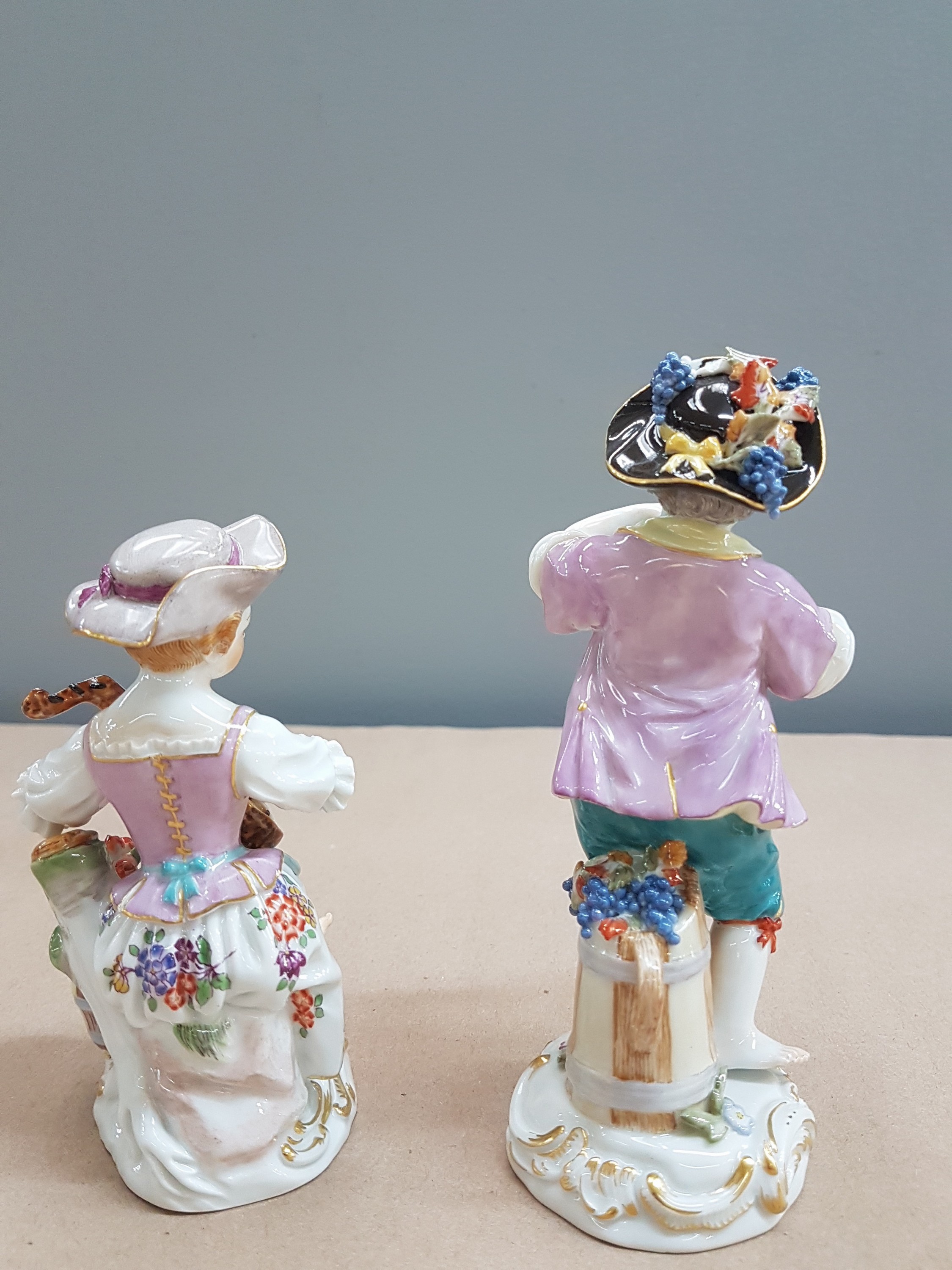 Detail c: 2 Porzellanfiguren, Meissen, 20. Jh., 1. Wahl, Mädchen mit Mandoline und Junge mit Flöte, bunt bemalt, Goldstaffage, H. ca. 11 bzw. 13.5cm, Hut des ...
