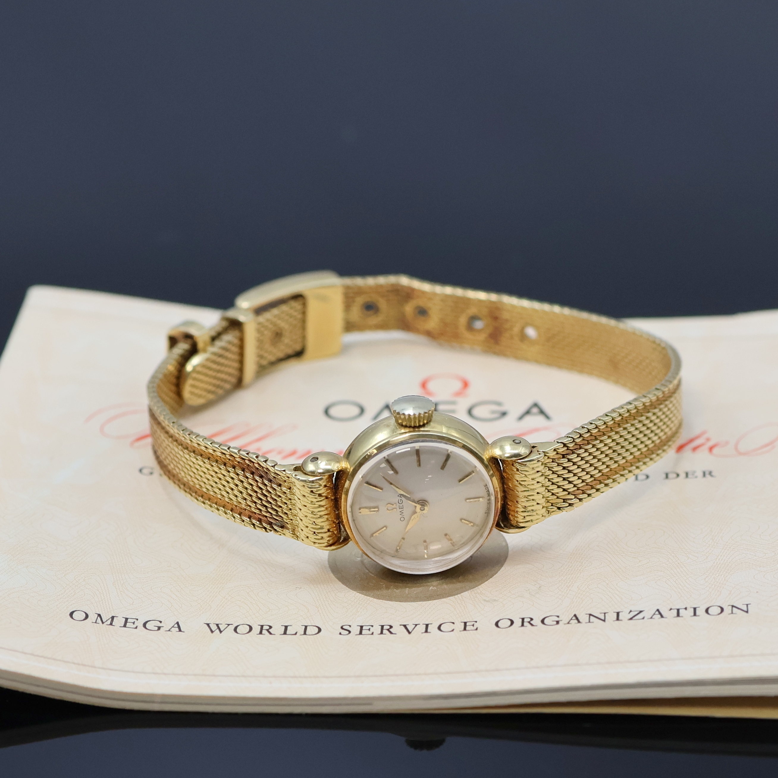 OMEGA aufwendige Damenarmbanduhr in GG 750/000, Handaufzug, Schweiz um 1960, Boden aufgedr., orig. Band in Form eines Gürtels, silbern. Zifferblatt ...