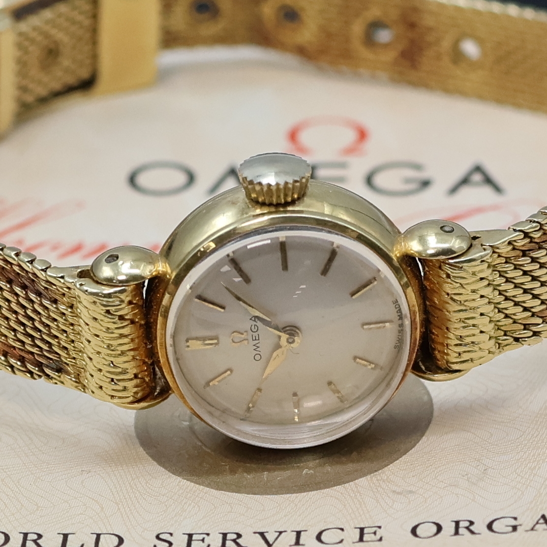 Detail a: OMEGA aufwendige Damenarmbanduhr in GG 750/000, Handaufzug, Schweiz um 1960, Boden aufgedr., orig. Band in Form eines Gürtels, silbern. Zifferblatt ...
