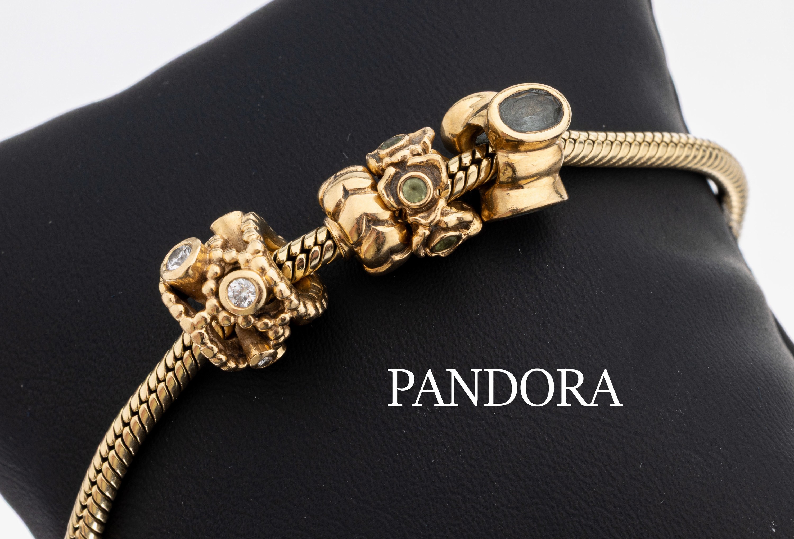 14 kt Gold PANDORA Armband, GG 585/000, 4 Charms in versch. Größen und Formen, 1 Charm mit 7 Brillanten zus. ca. 0.15 ct Weiß/si, L. ca. 21.5 cm, ...