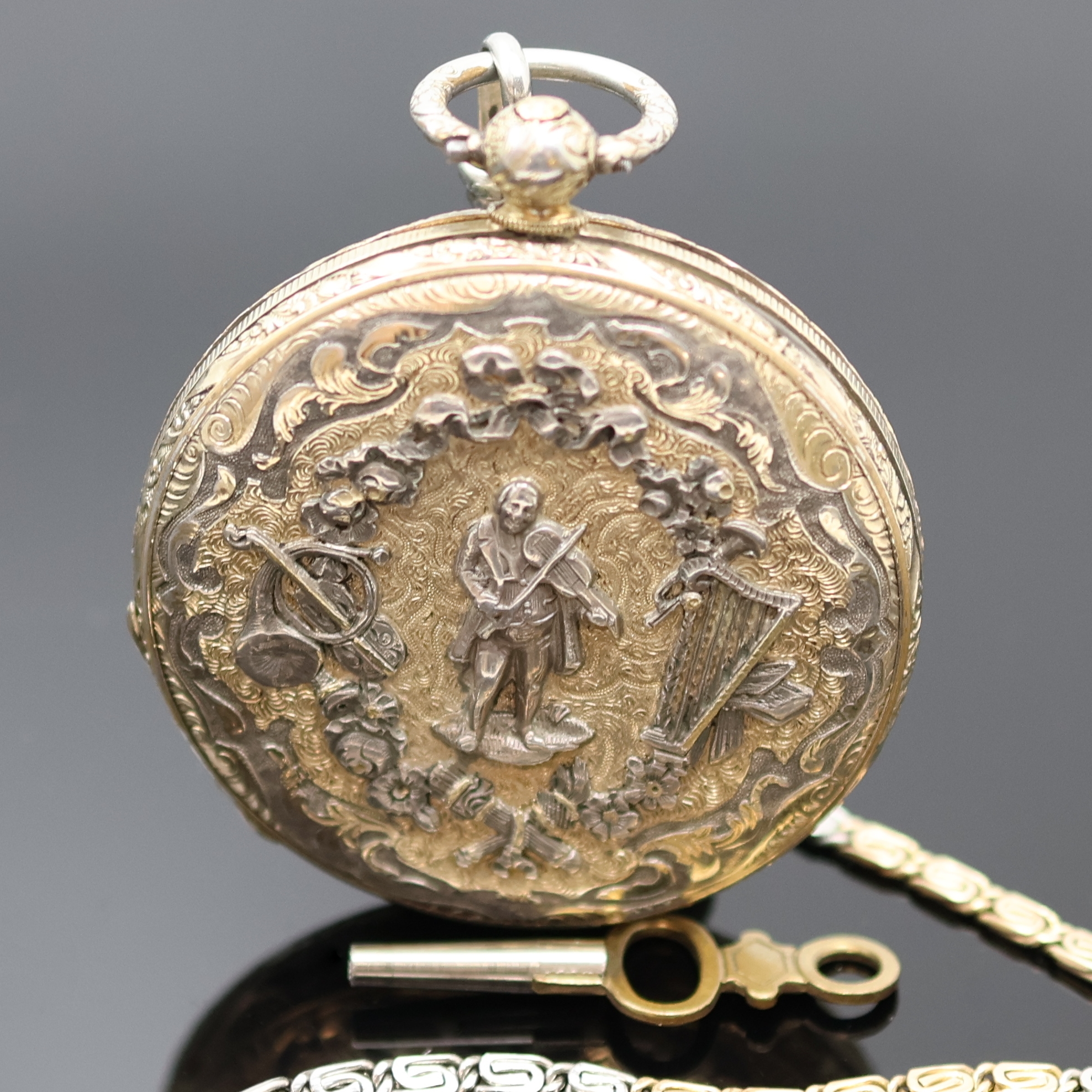 Detail b: Reich verzierte, offene Silbertaschenuhr an späterer Kette in Platin/RG 750/000, Schweiz um 1840, Geh. teils verg., Emailzifferbl. riss., röm. ...