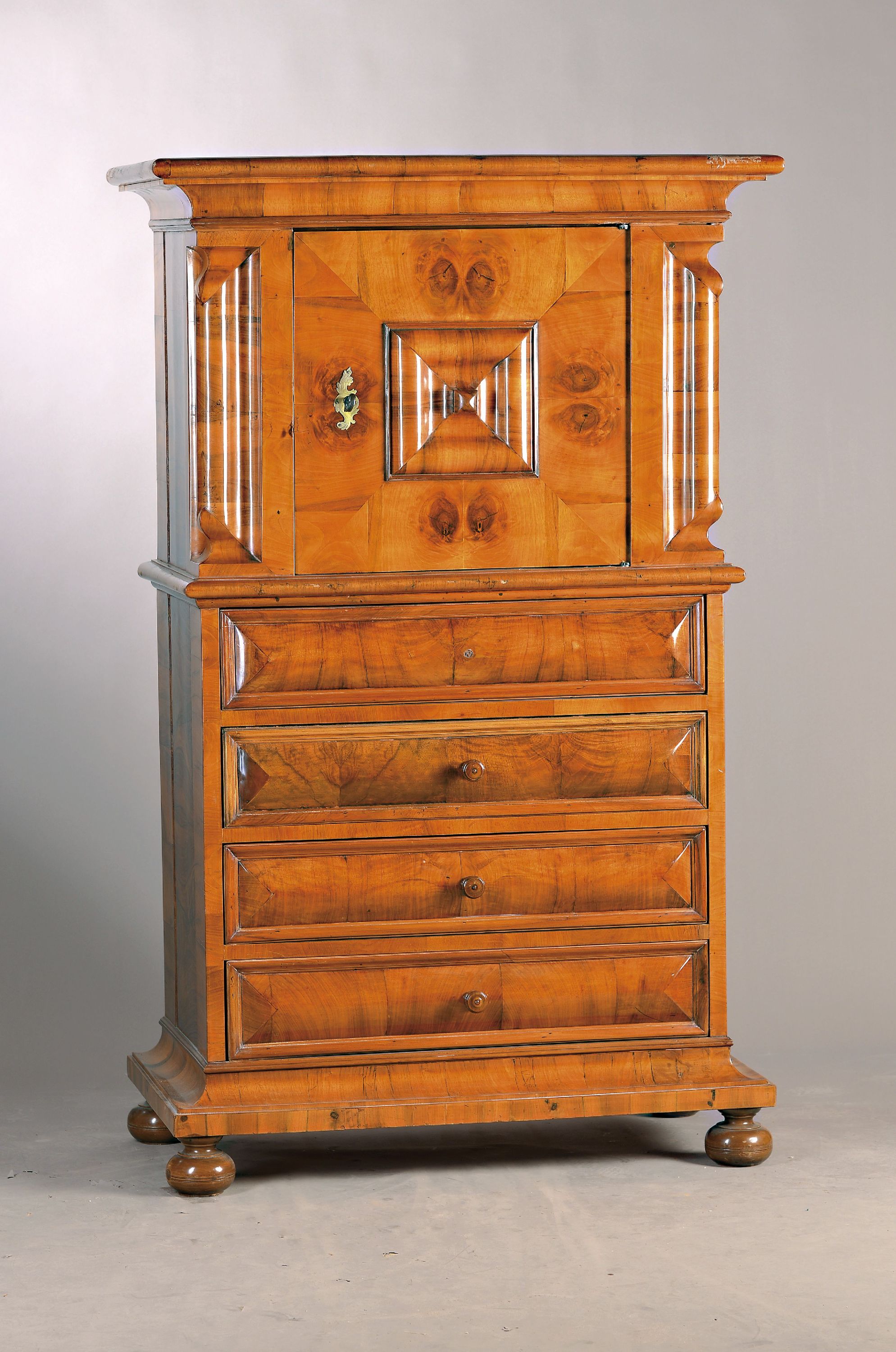 Windellade, Barock, um 1750/60, Nussbaumfurnier, z.T. Wurzelnuss, vier Schubladen (ein Knauf fehlt), eine Tür, orig. Schloß, Schlüssel, stiltyp. ...