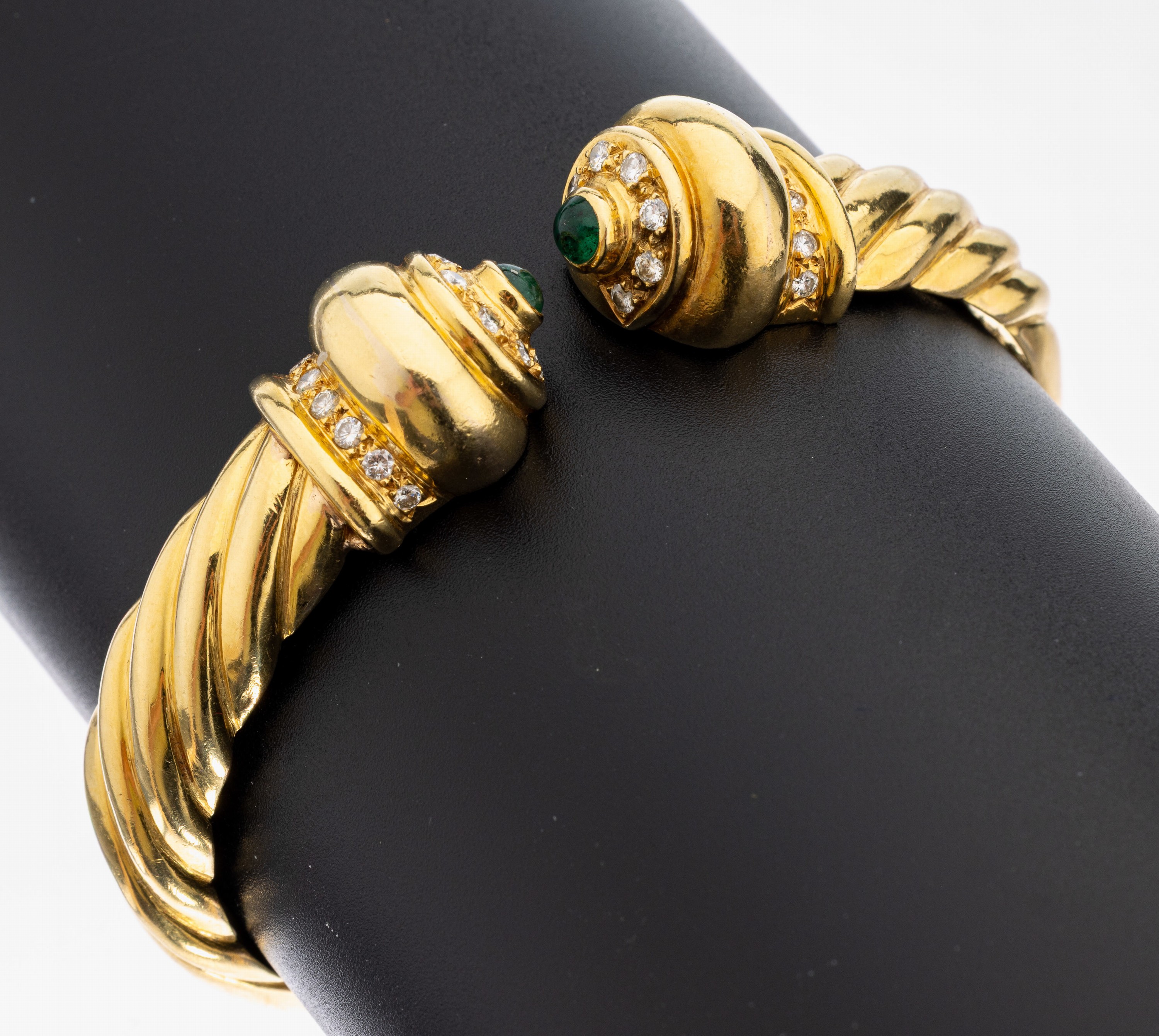 18 kt Gold Brillant-Smaragd-Armspange, GG 750/000, 28 Brillanten zus. ca. 0.80 ct Weiß/si, 2 Smaragd-Cabochons zus. ca. 0.22 ct,1 Stein besch., D. ...