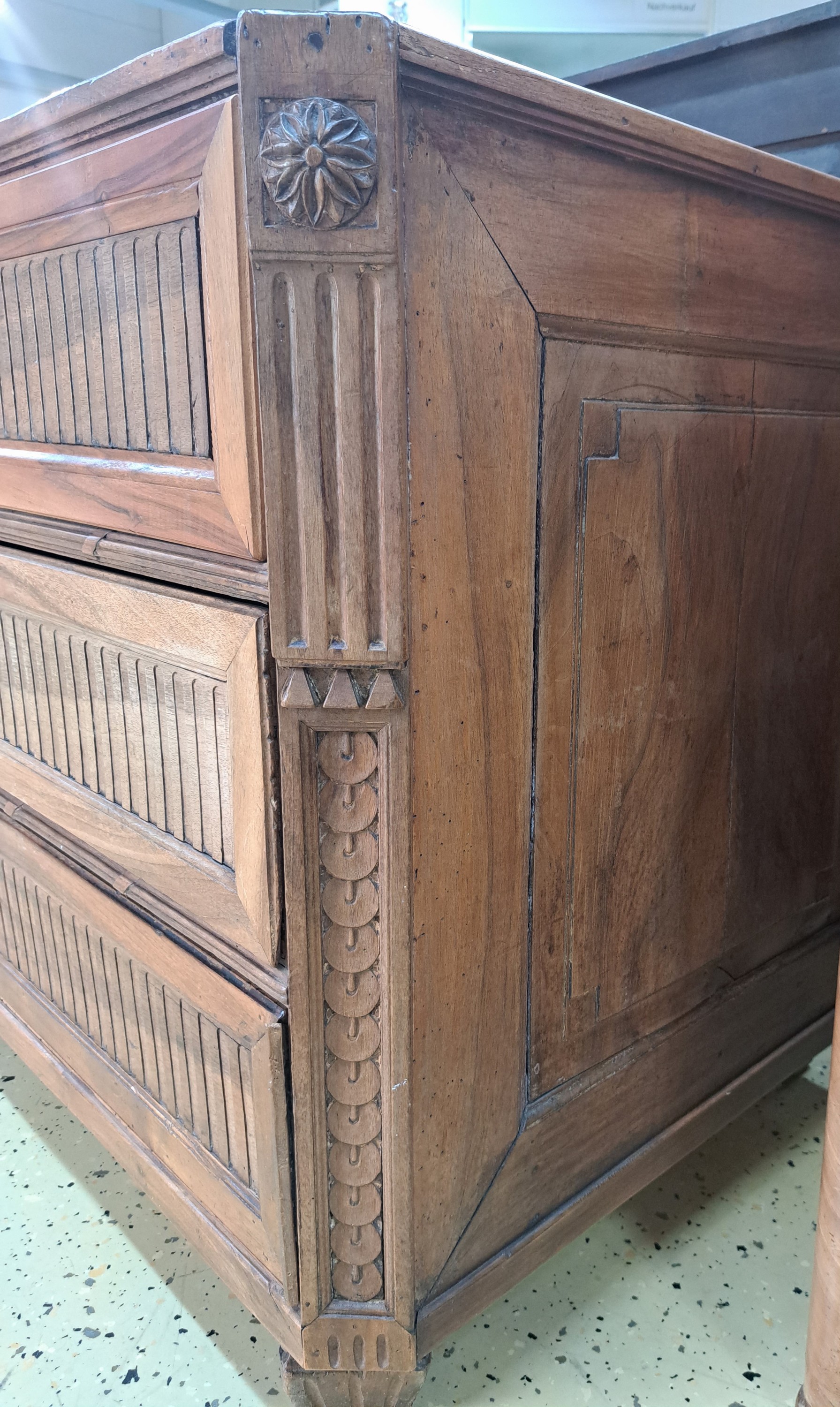 Detail e: Klassizistische Kommode, um 1800/20, Nussbaum massiv, drei Schubladen, kassettiert, kannelierte Dekor, ohne Marmorplatte, 82 x 127 x 63 cm, EZ 3