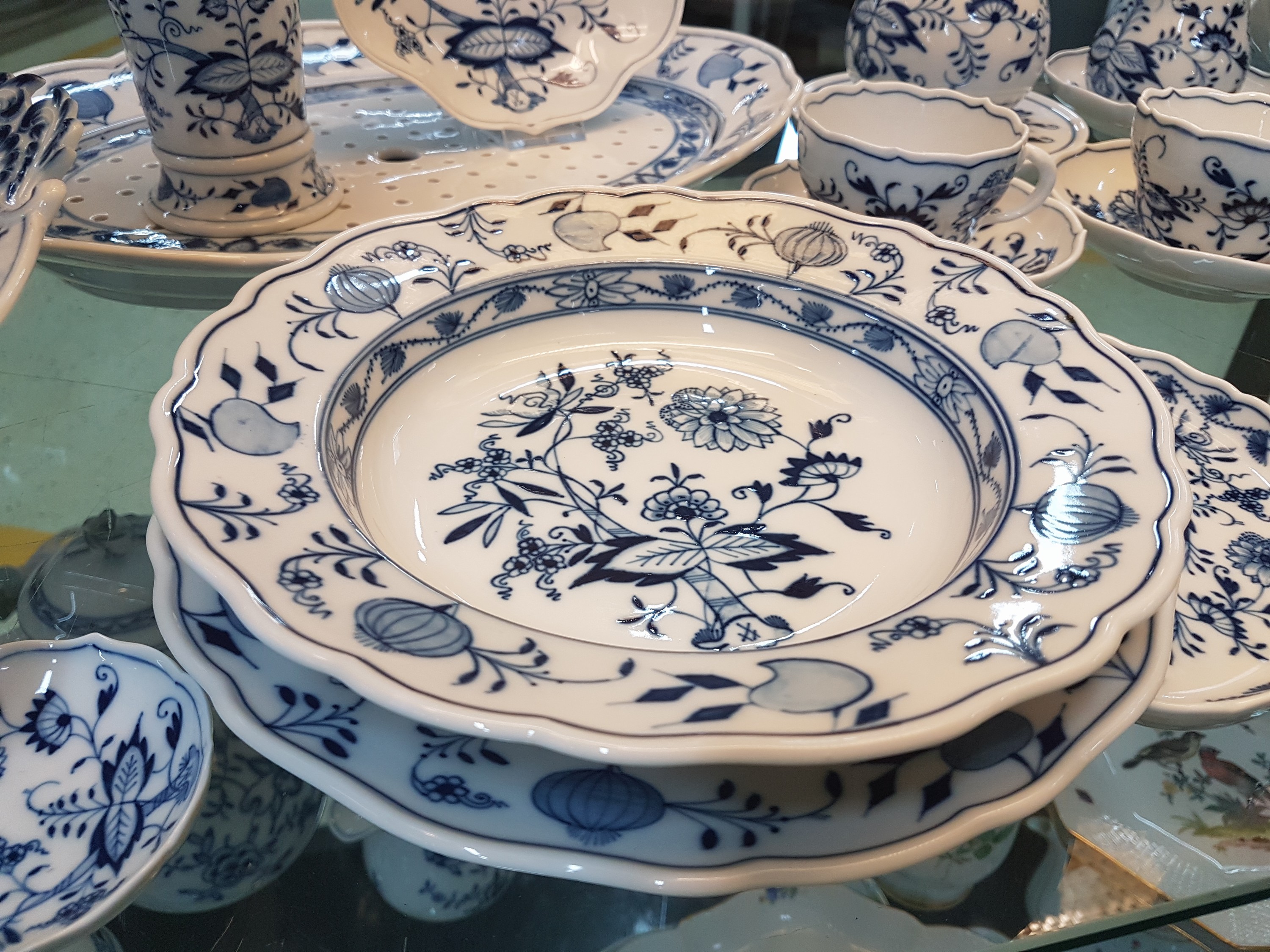 Detail b: Tafelservice, Meissen, meist um 1880, Porzellan, Zwiebelmuster, Deckelschüssel am Griff l. besch., 2 Gemüseschüsseln, eine Platte mit Siebeinsatz, ...