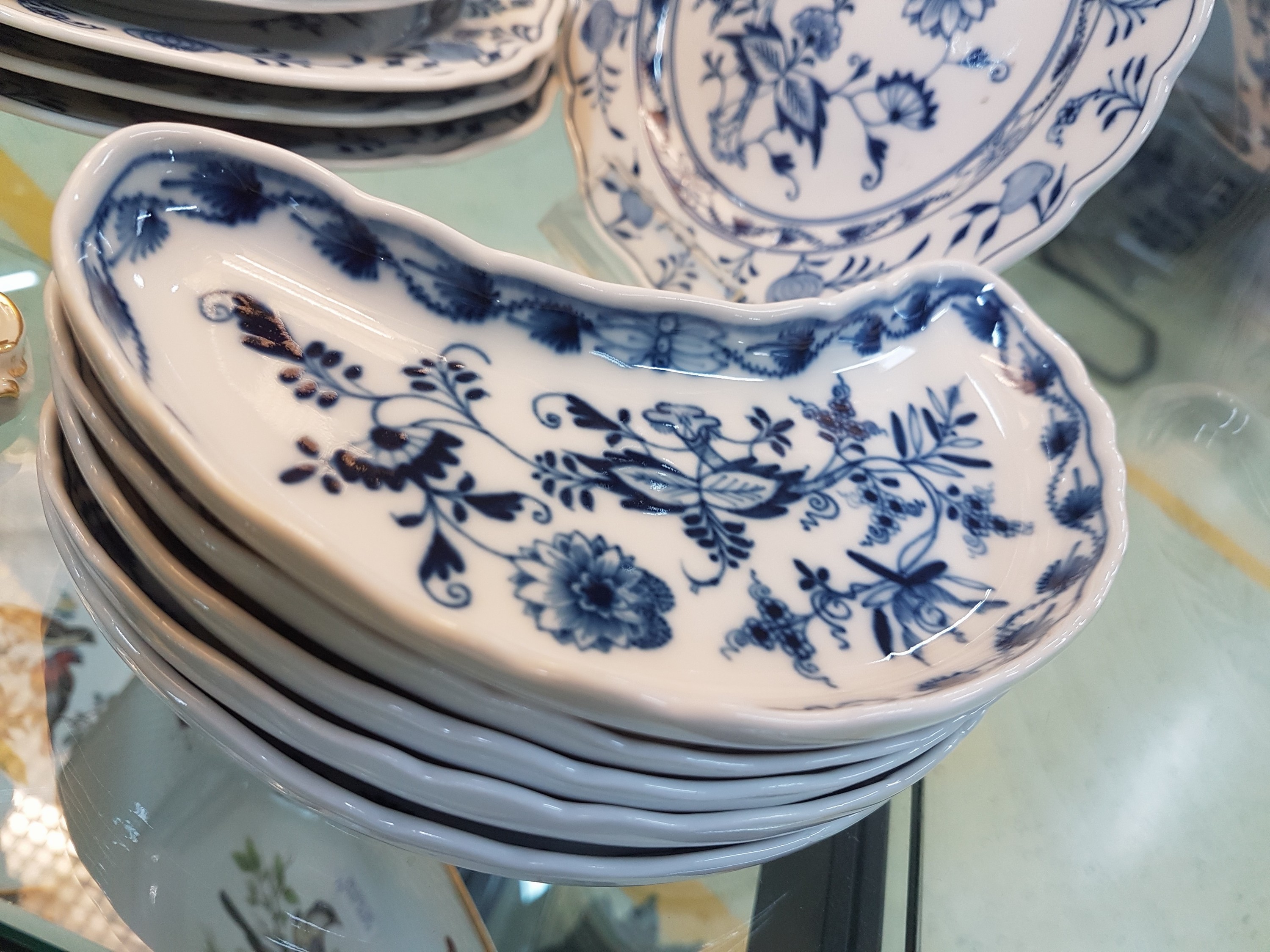 Detail g: Tafelservice, Meissen, meist um 1880, Porzellan, Zwiebelmuster, Deckelschüssel am Griff l. besch., 2 Gemüseschüsseln, eine Platte mit Siebeinsatz, ...