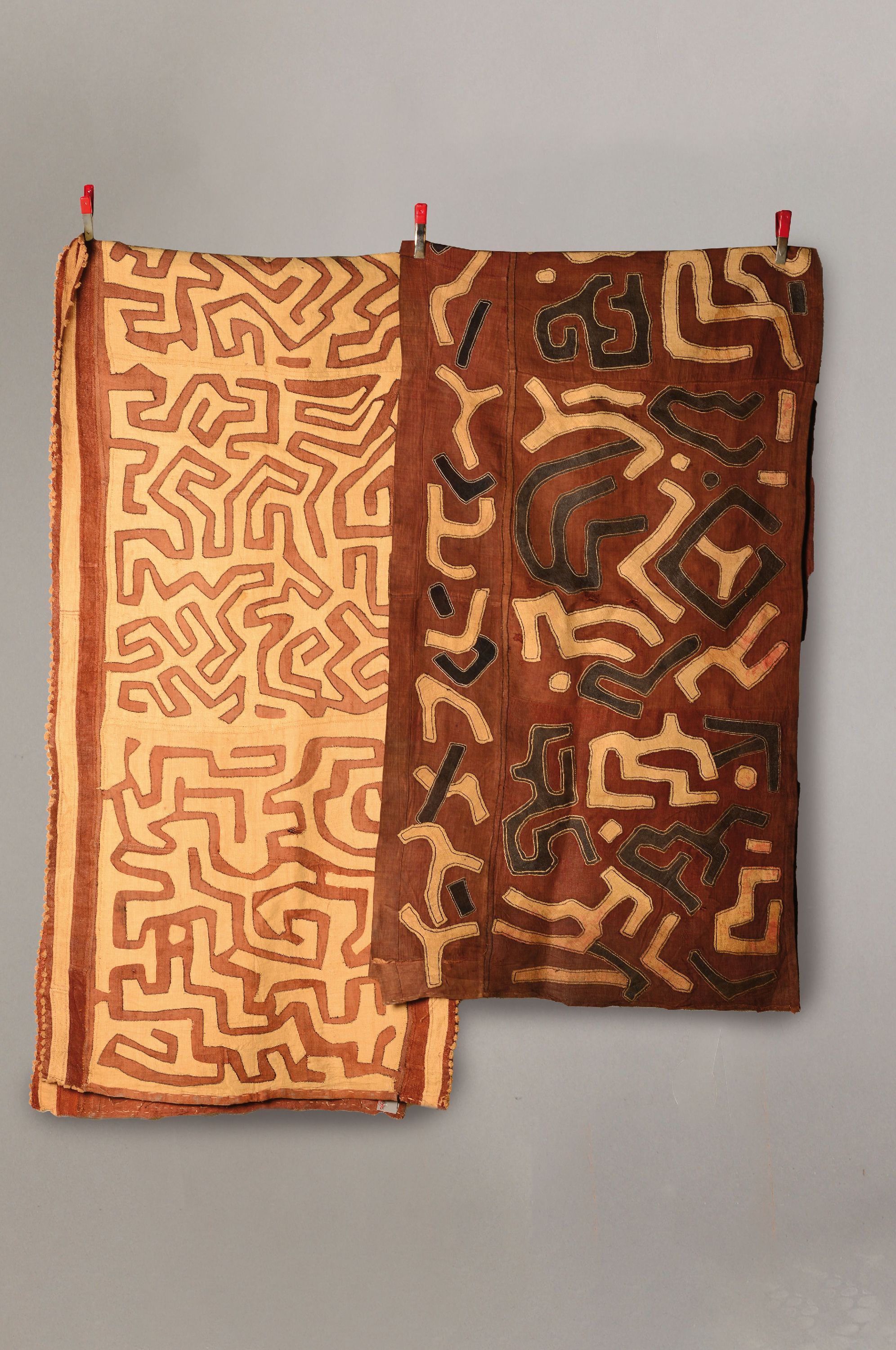 2 Wickelröcke oder Tanzkleider, Raffia-Gewebe, Kuba/Bushong, Kongo, um Anfang 20. Jh., roter Grundstoff mit aufgenähtem sandfarbenen Linienmuster, ...
