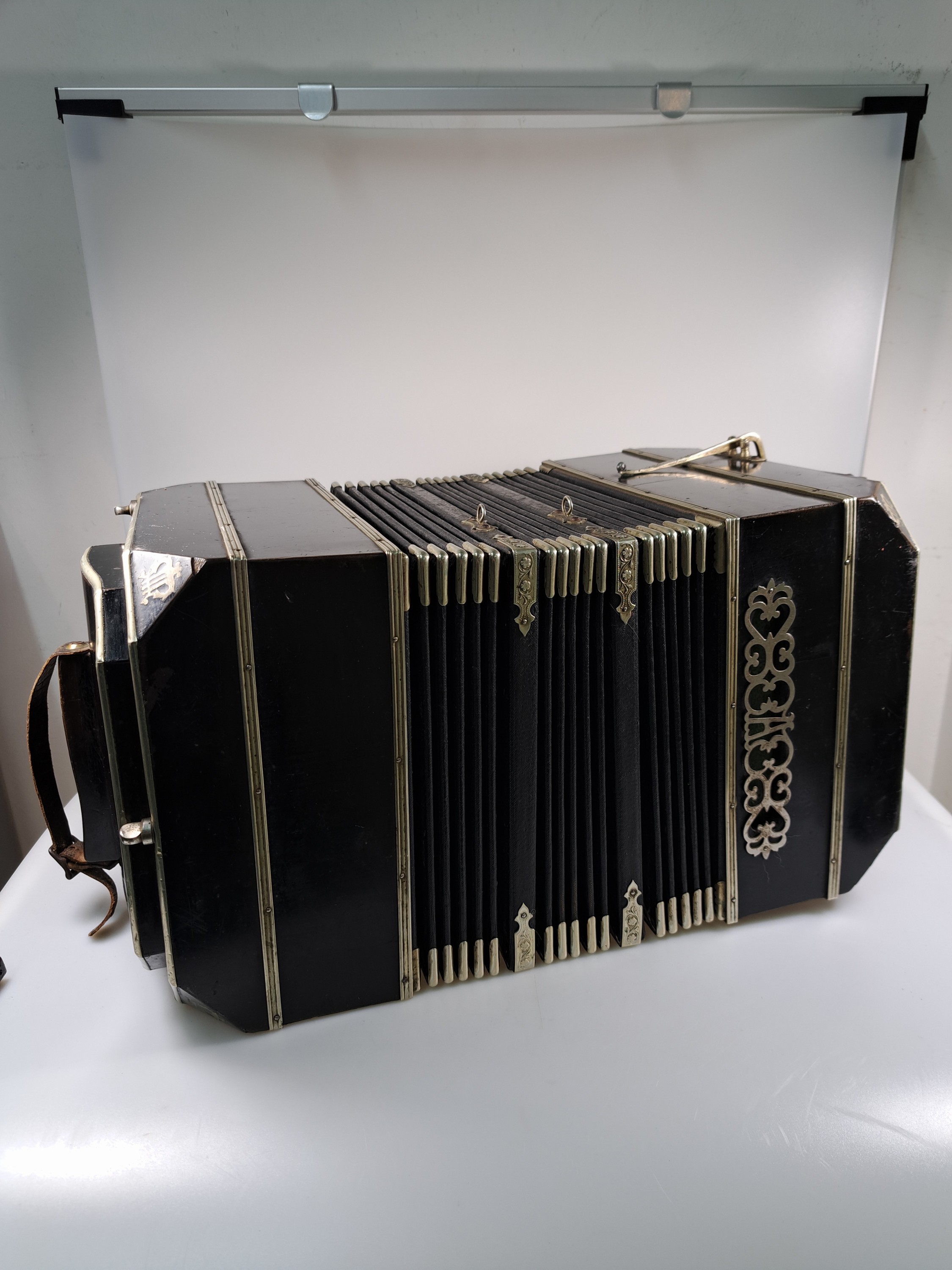 Detail a: Bandoneon, wohl Alfred Arnold, 1.H. 20. Jh., Holzgehäuse mit Lyraeinlagen in Metall an den abgeschrägten Ecken, Laubsägearbeiten seitliche mit ...