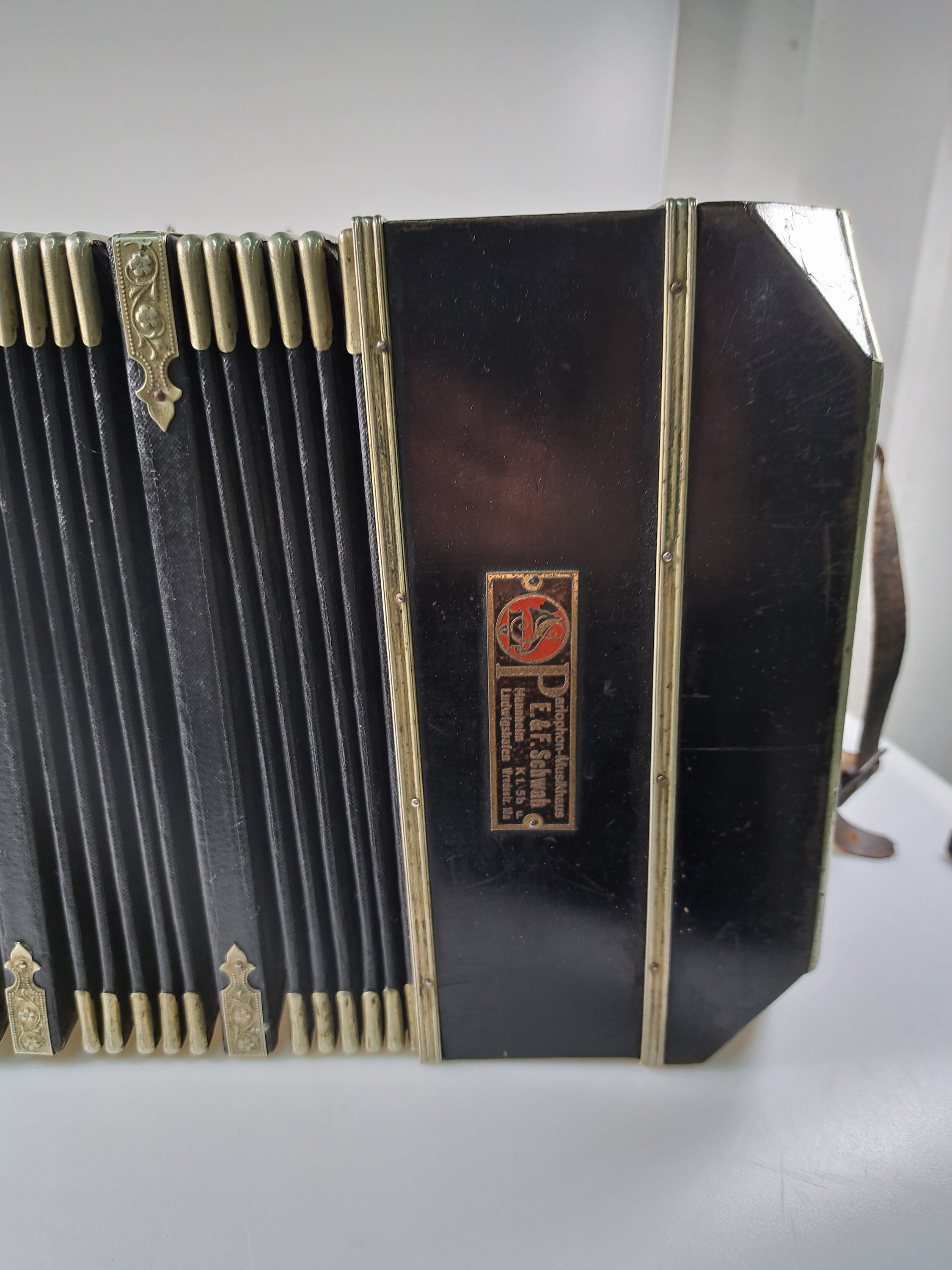 Detail c: Bandoneon, wohl Alfred Arnold, 1.H. 20. Jh., Holzgehäuse mit Lyraeinlagen in Metall an den abgeschrägten Ecken, Laubsägearbeiten seitliche mit ...