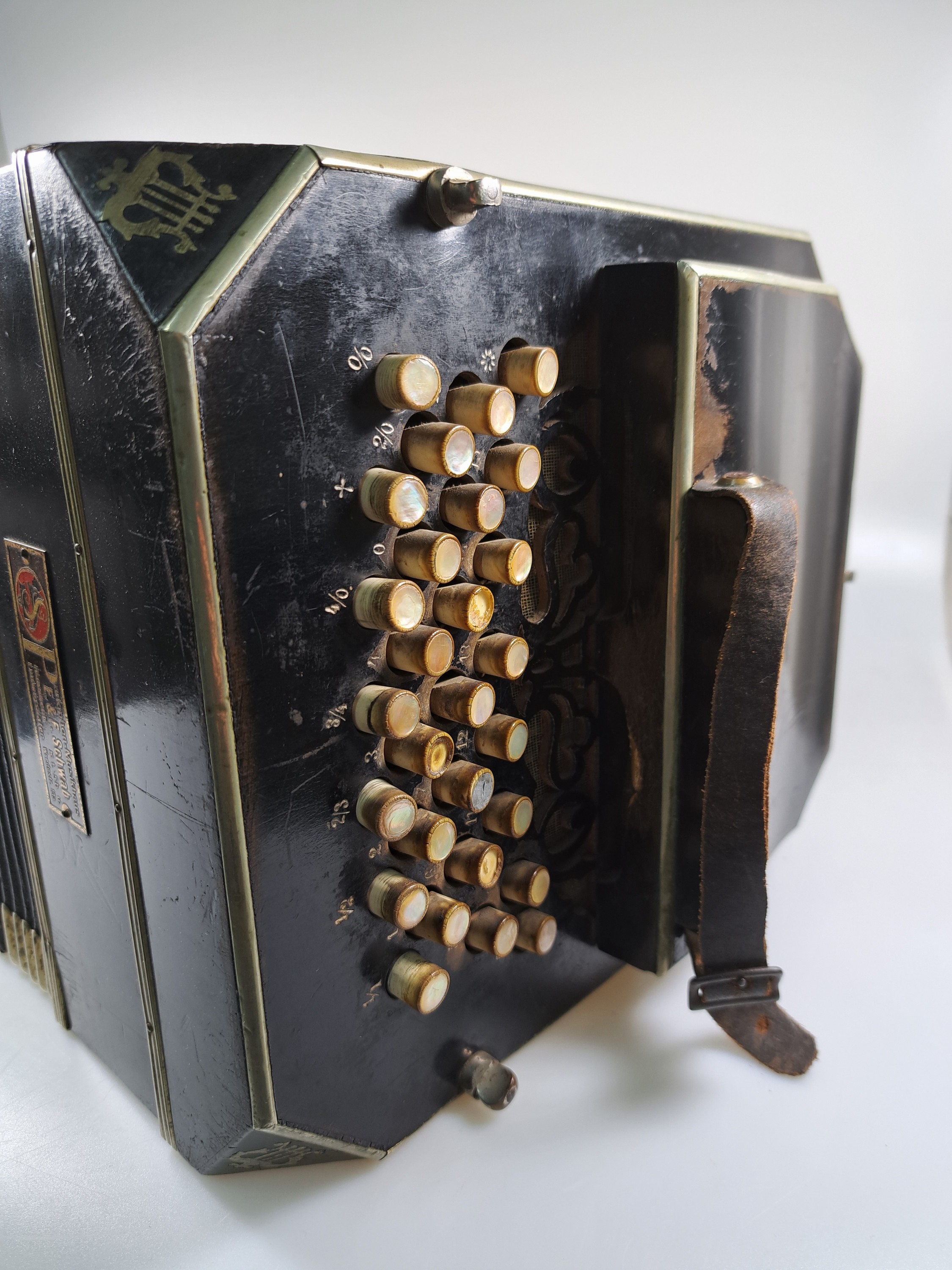Detail d: Bandoneon, wohl Alfred Arnold, 1.H. 20. Jh., Holzgehäuse mit Lyraeinlagen in Metall an den abgeschrägten Ecken, Laubsägearbeiten seitliche mit ...