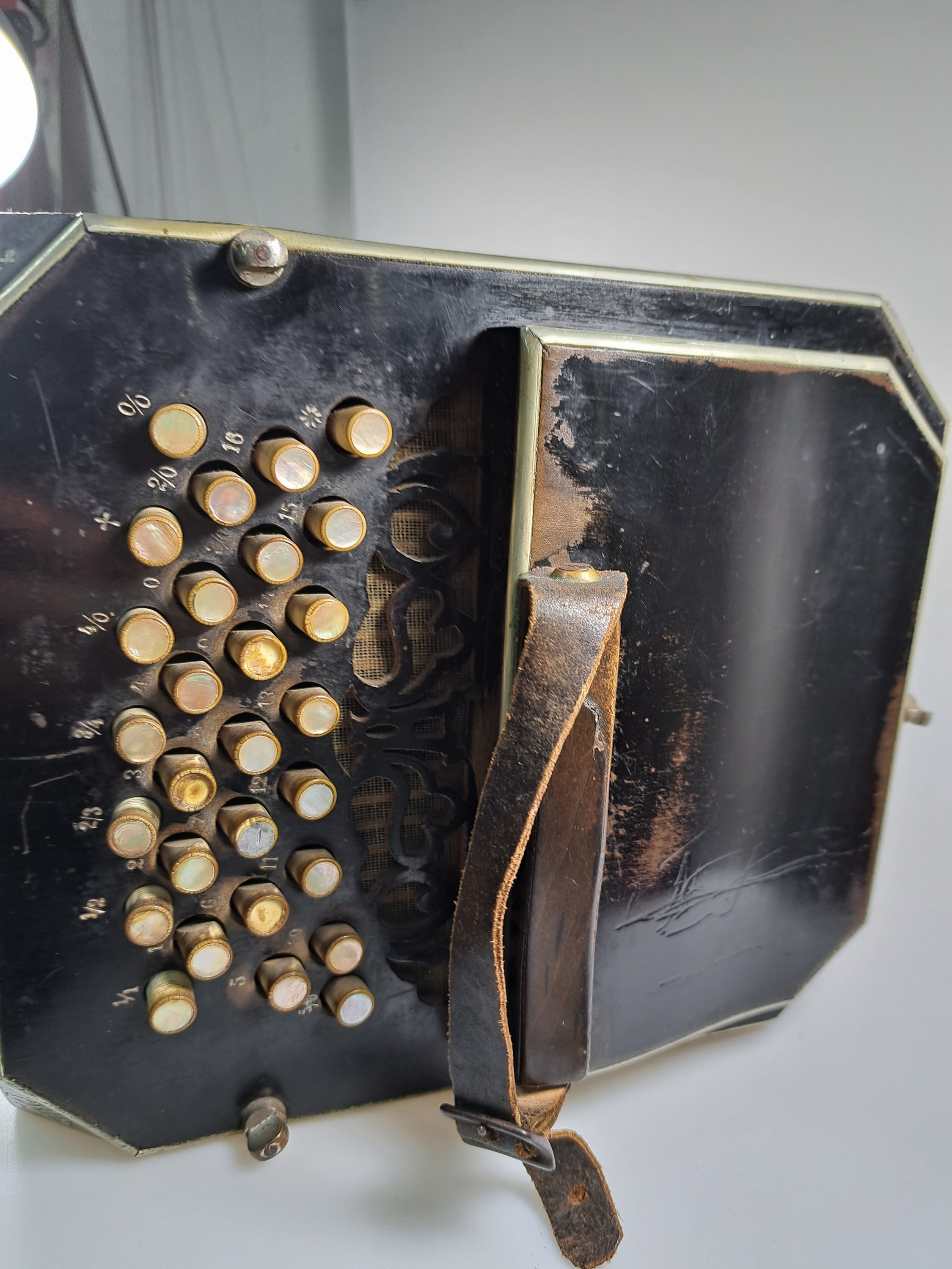 Detail e: Bandoneon, wohl Alfred Arnold, 1.H. 20. Jh., Holzgehäuse mit Lyraeinlagen in Metall an den abgeschrägten Ecken, Laubsägearbeiten seitliche mit ...