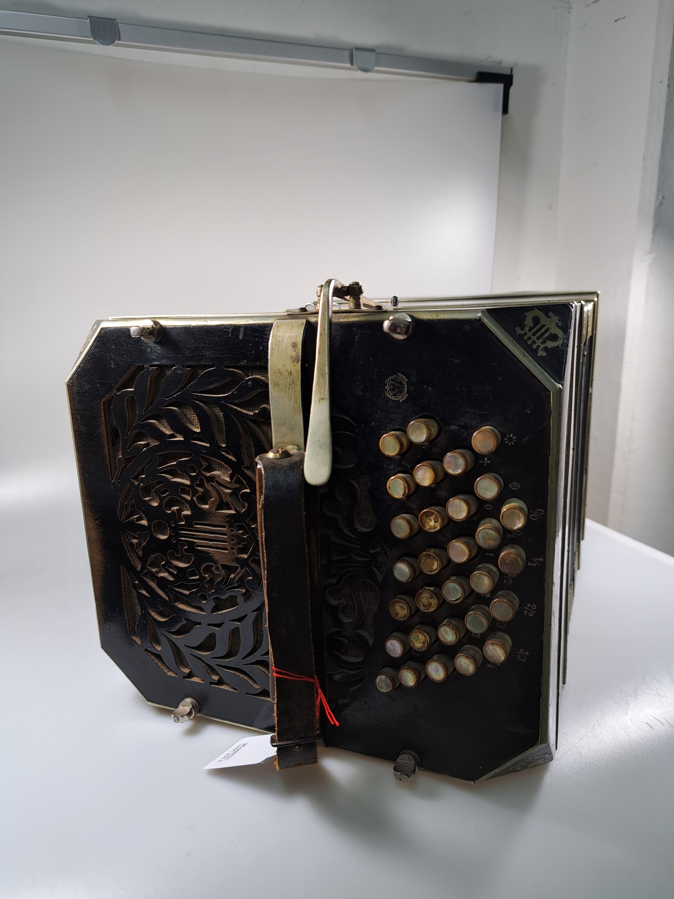 Detail g: Bandoneon, wohl Alfred Arnold, 1.H. 20. Jh., Holzgehäuse mit Lyraeinlagen in Metall an den abgeschrägten Ecken, Laubsägearbeiten seitliche mit ...