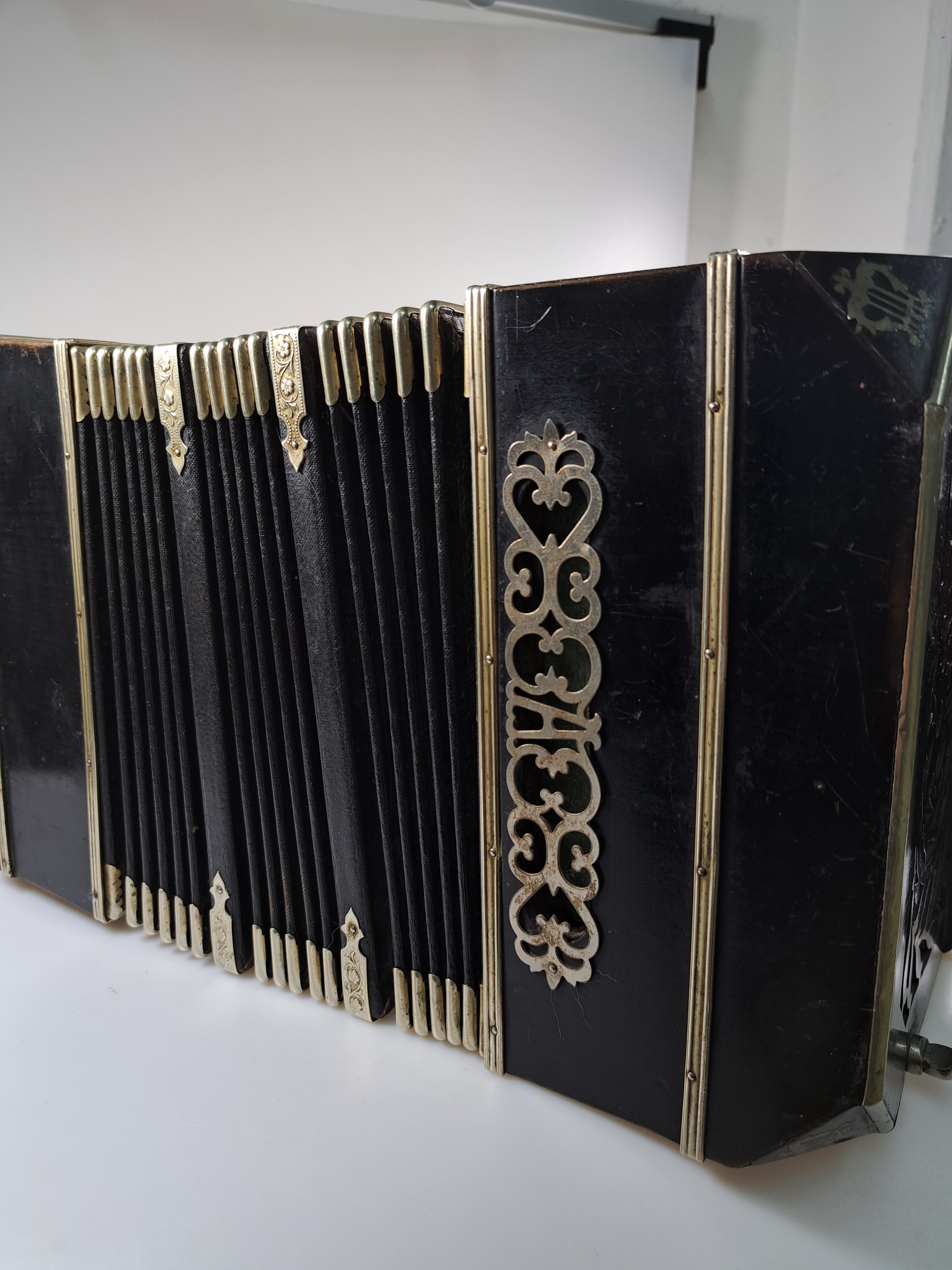 Detail i: Bandoneon, wohl Alfred Arnold, 1.H. 20. Jh., Holzgehäuse mit Lyraeinlagen in Metall an den abgeschrägten Ecken, Laubsägearbeiten seitliche mit ...