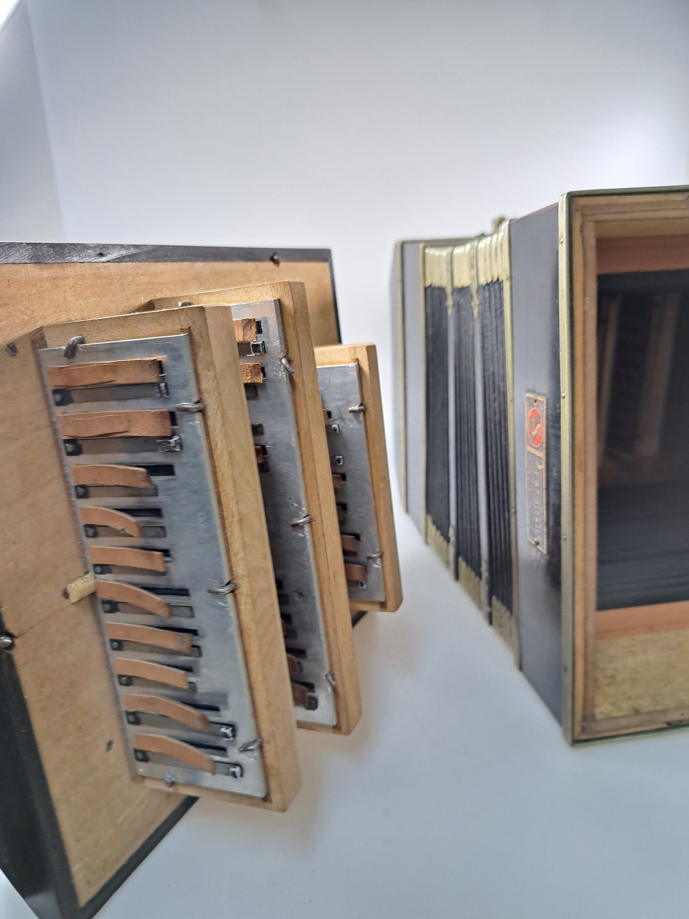 Detail k: Bandoneon, wohl Alfred Arnold, 1.H. 20. Jh., Holzgehäuse mit Lyraeinlagen in Metall an den abgeschrägten Ecken, Laubsägearbeiten seitliche mit ...