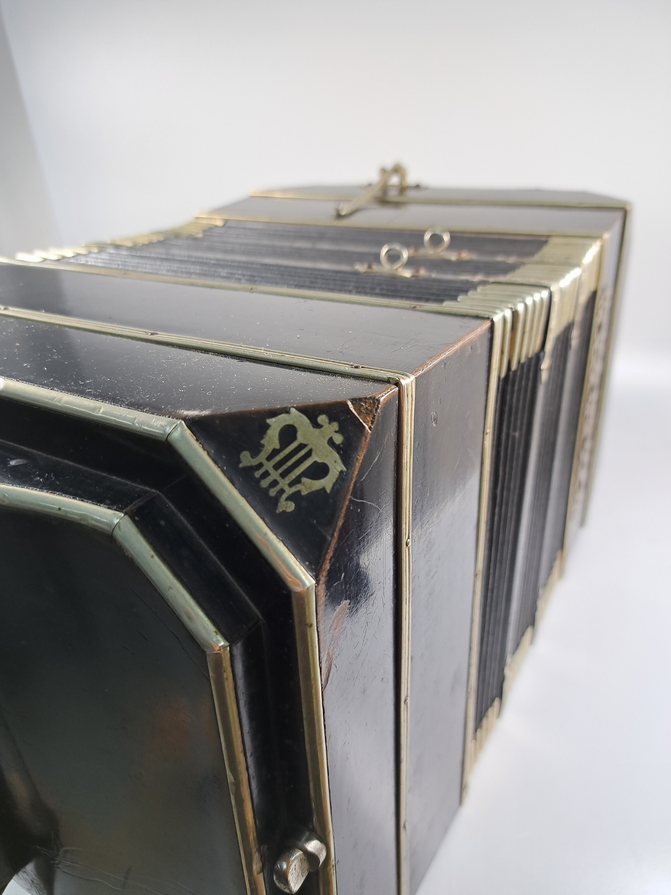 Detail m: Bandoneon, wohl Alfred Arnold, 1.H. 20. Jh., Holzgehäuse mit Lyraeinlagen in Metall an den abgeschrägten Ecken, Laubsägearbeiten seitliche mit ...