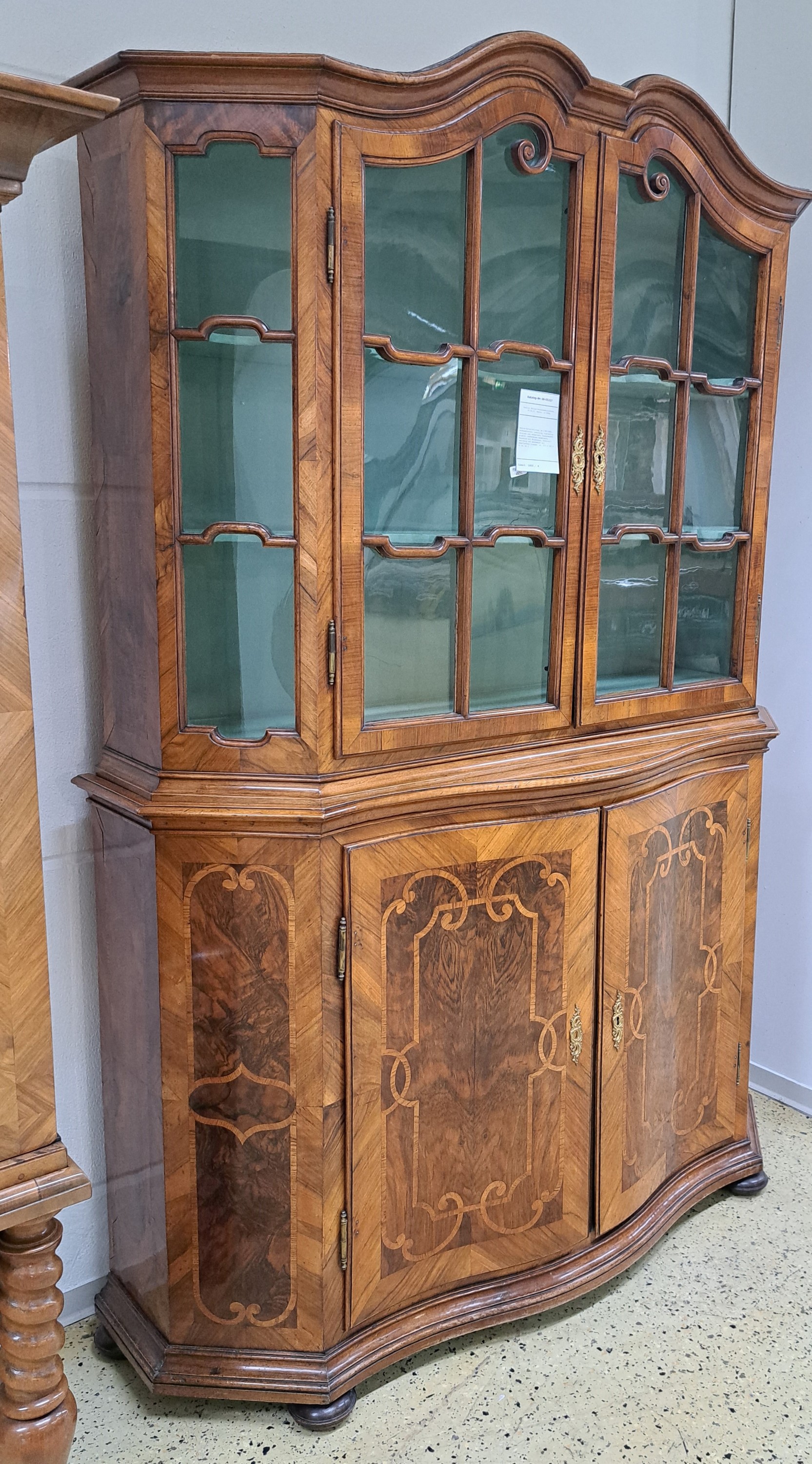 Detail a: Barock-Aufsatzvitrine, um 1780/1800, Nußbaumfurnier, zweitürig, vierseitig verglast und versprosst, Glasscheiben ergänzt, aufwendiges Bandelwerk, ...