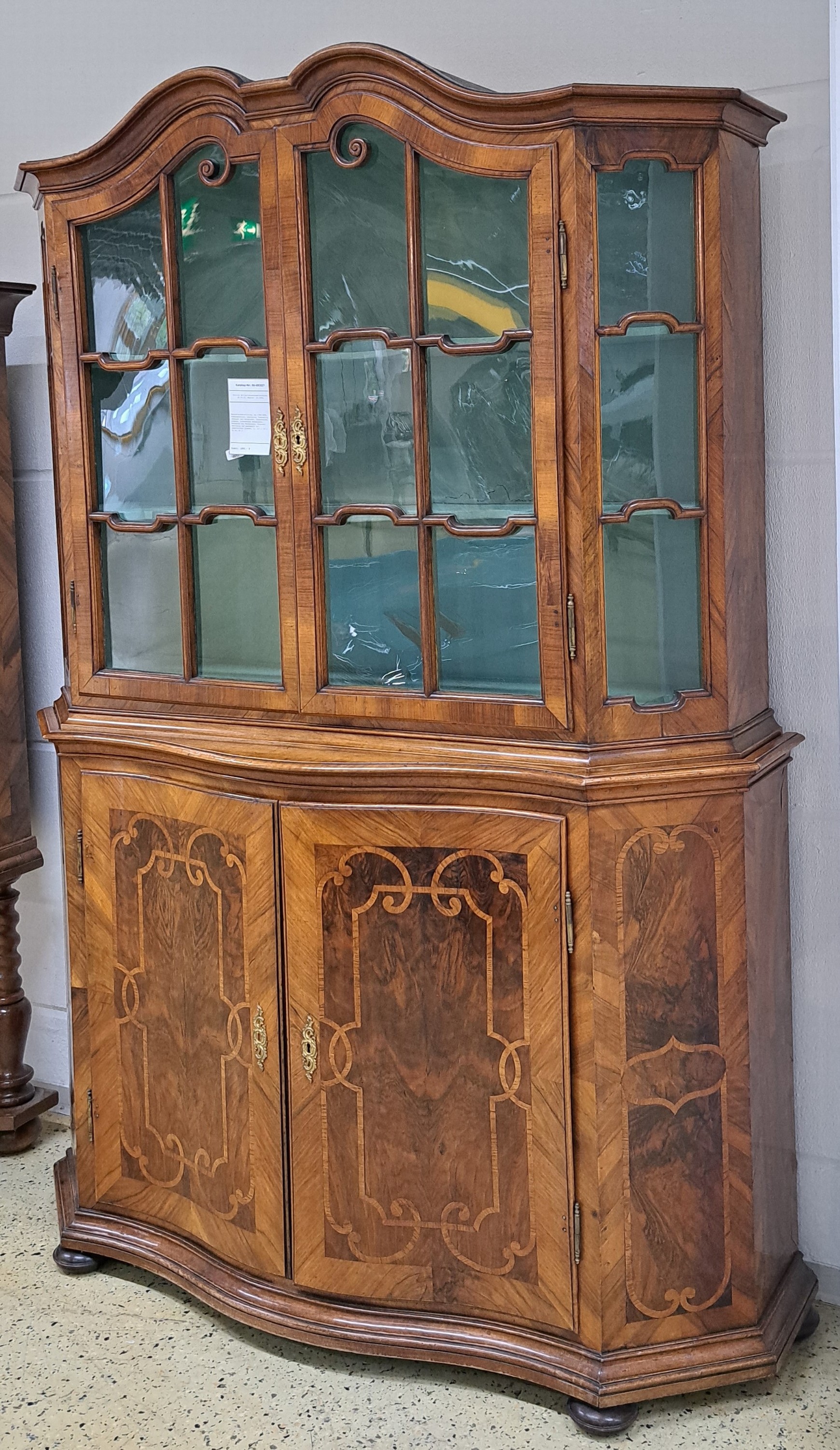 Detail b: Barock-Aufsatzvitrine, um 1780/1800, Nußbaumfurnier, zweitürig, vierseitig verglast und versprosst, Glasscheiben ergänzt, aufwendiges Bandelwerk, ...