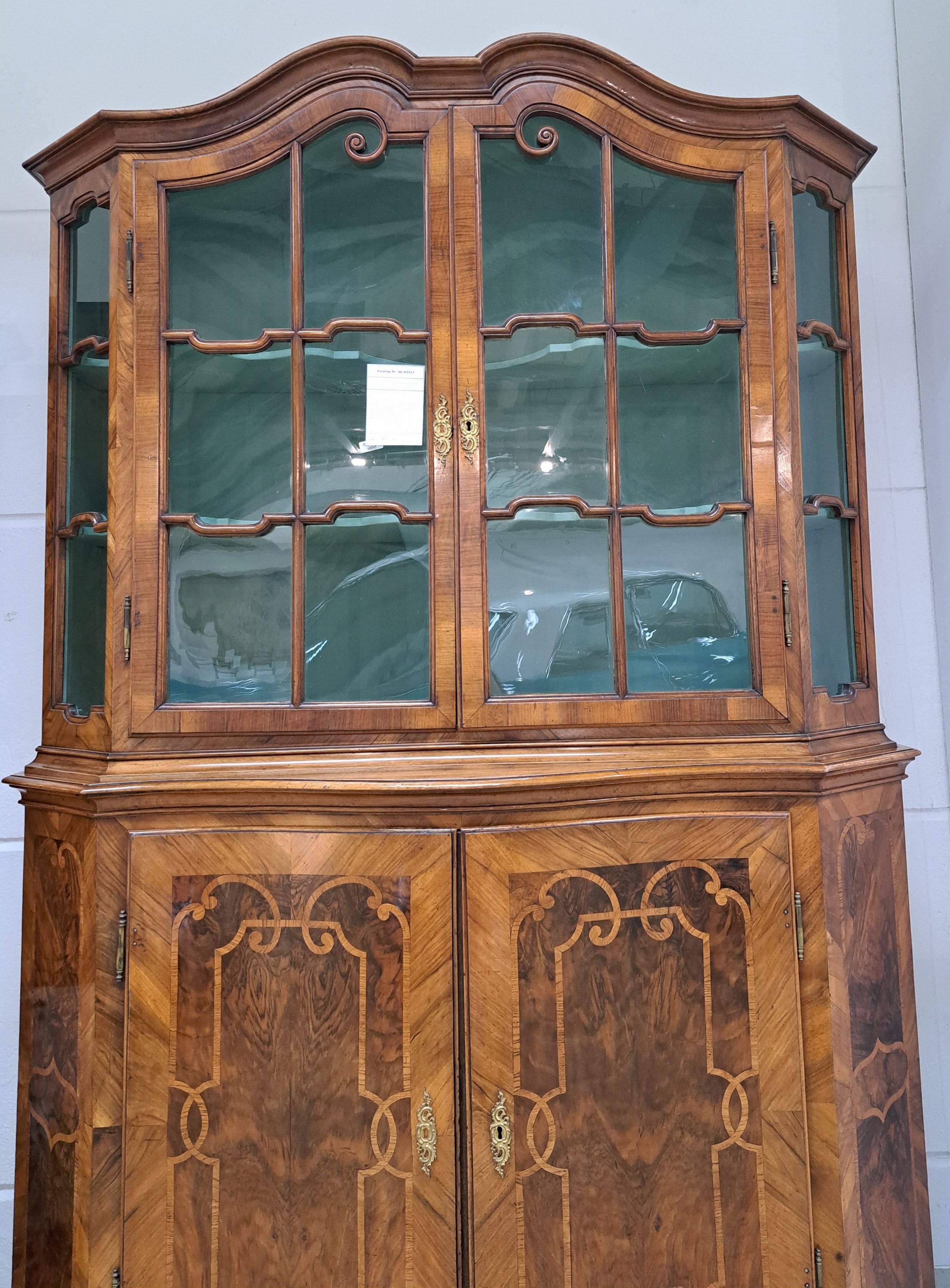 Detail c: Barock-Aufsatzvitrine, um 1780/1800, Nußbaumfurnier, zweitürig, vierseitig verglast und versprosst, Glasscheiben ergänzt, aufwendiges Bandelwerk, ...