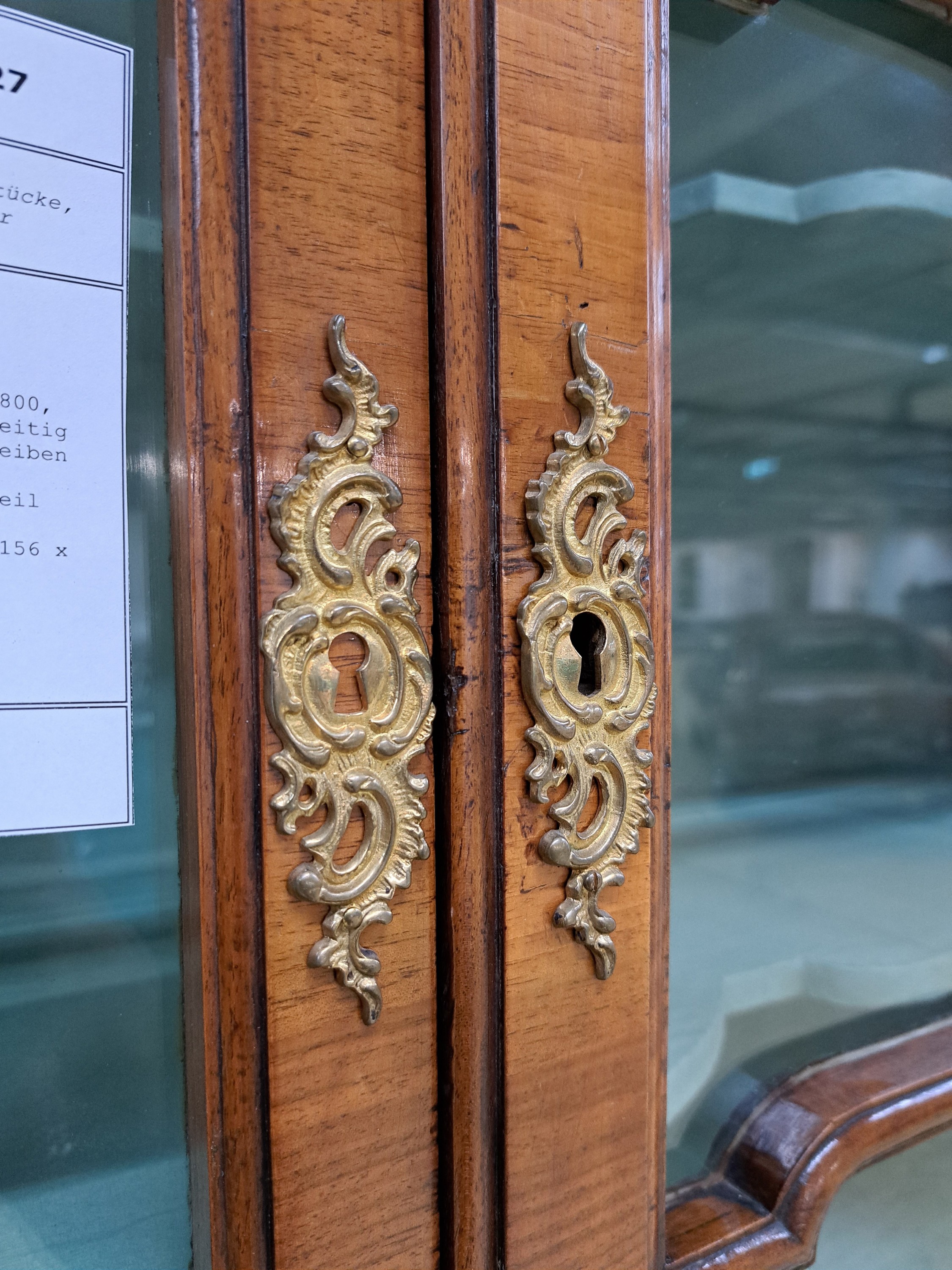 Detail e: Barock-Aufsatzvitrine, um 1780/1800, Nußbaumfurnier, zweitürig, vierseitig verglast und versprosst, Glasscheiben ergänzt, aufwendiges Bandelwerk, ...