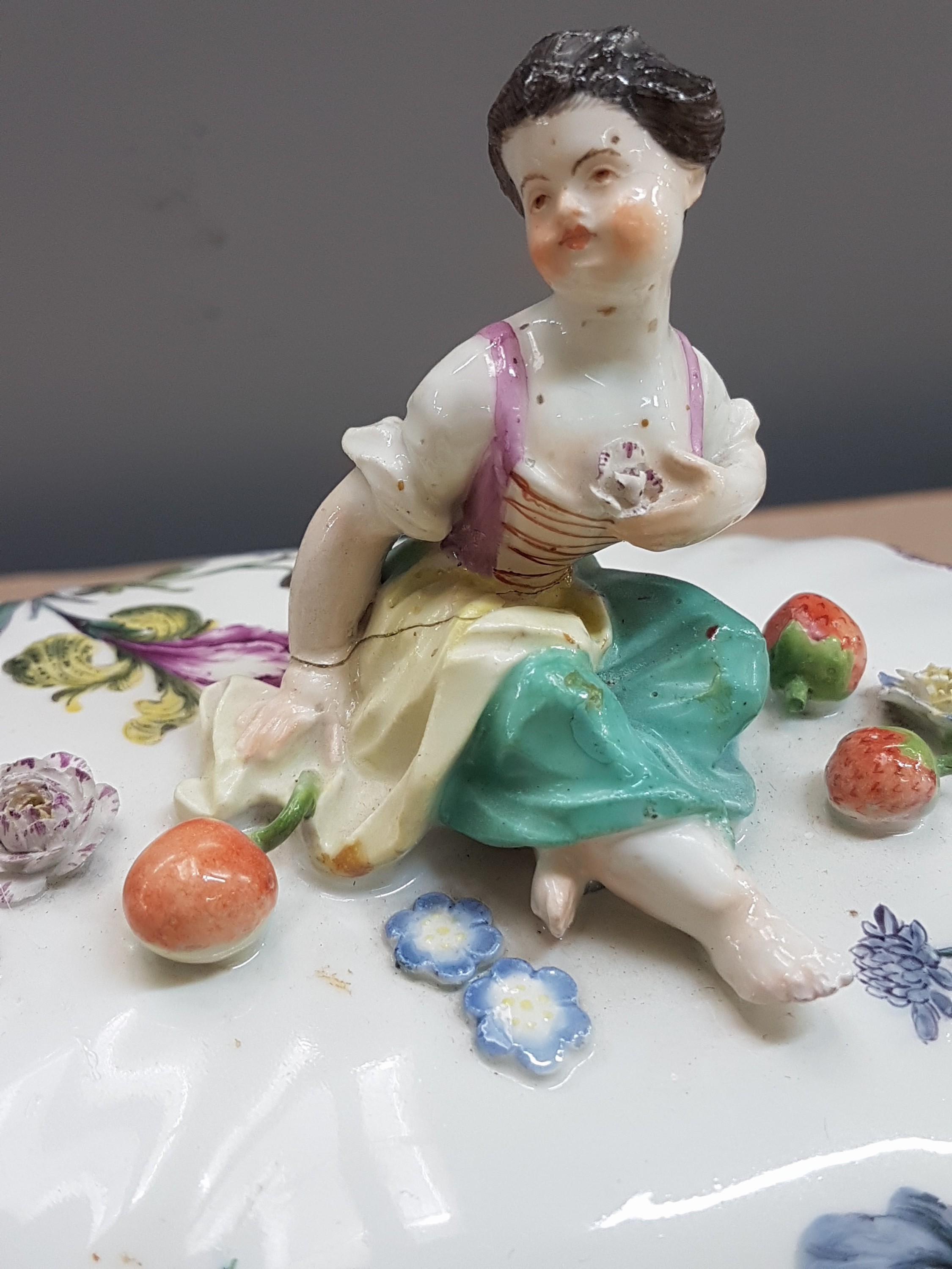 Detail b: Deckelgefäss mit Figurenbekrönung, Meissen, um 1760, Fahne mit Korbrelief, bekrönt mit kleiner Gärtnerin u. appliziertem Obst u. Blümchen, ...