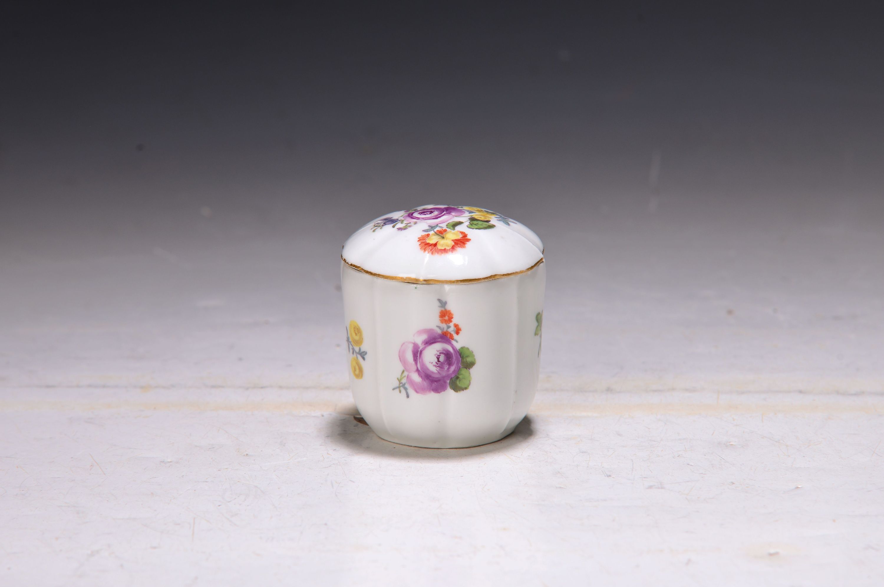 Detail b: Kleine Deckeldose, Meissen, 18. Jh., Porzellan, Vierpassform, qualitätvolle polychrome Bemalung, H.ca. 6.5 cm, Goldrand min. ber., selten, sammelw.