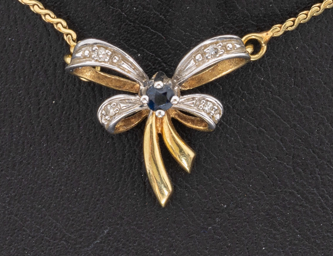 Detail a: 14 kt Gold Diamant-Saphir-Collier, GG/WG 585/000, Mittelteil in Form einer Schleife, mittig kl. rundfacett. Saphir, 4 kl. 8/8- Diamanten, L. ca. ...