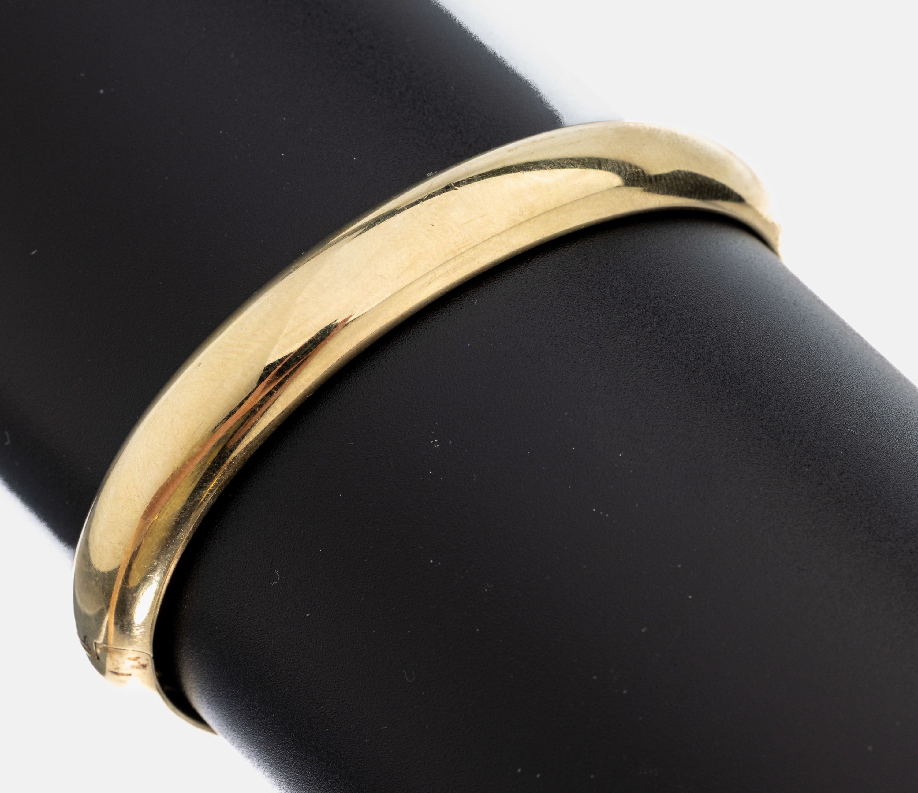 14 kt Gold Armreif, GG 585/000, gefüllt, schlicht, B. ca. 10 mm, D. ca. 6.3 x 5.3 cm, Kastenschloss mit Sicherheitsacht, ca. 31.3 g