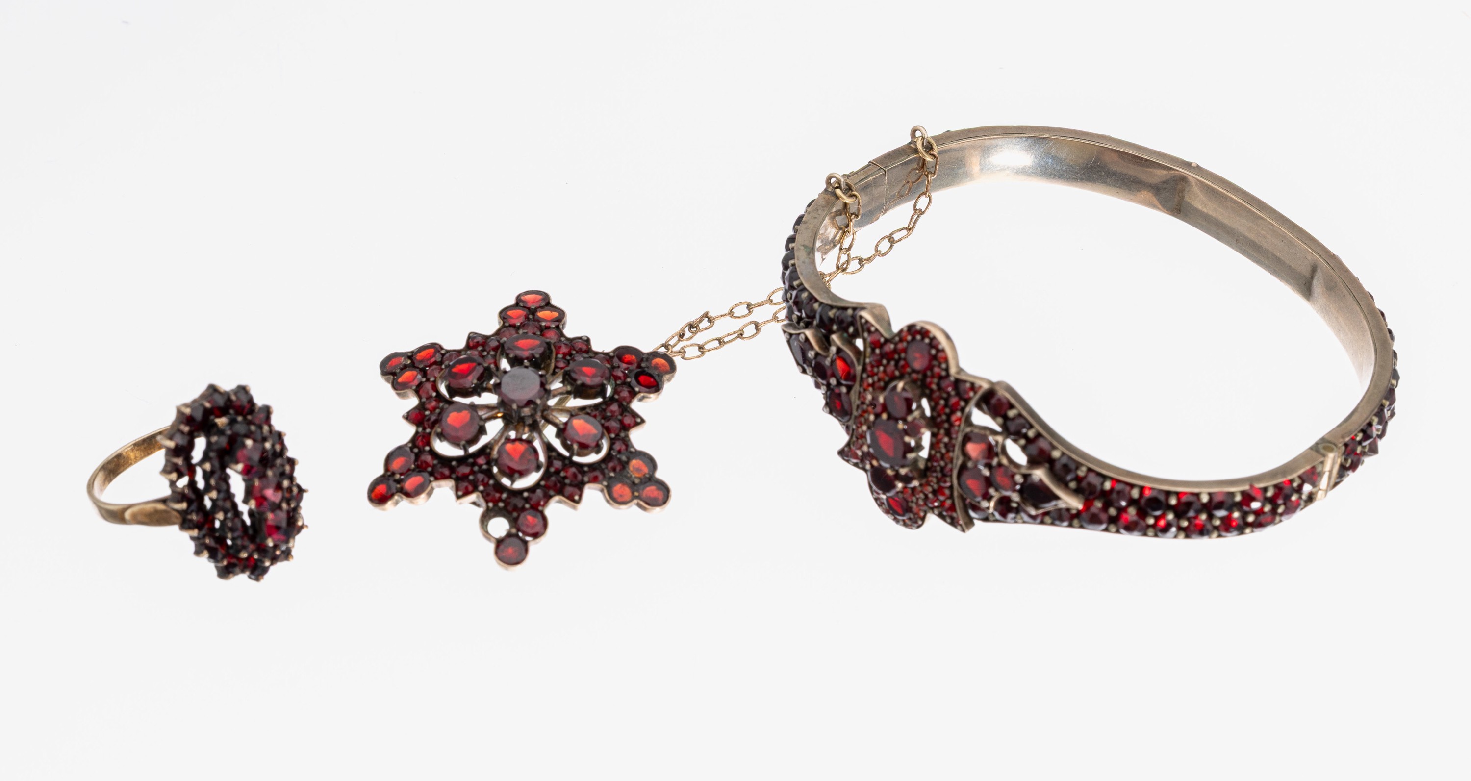 Granat-Konvolut, Böhmen um 1900, Metall verg., best. aus: 1 Ring, RW 53, 1 Armreif, D.ca. 5.7 x 5.2 cm, Klappscharnier, Kastenschloss mit ...
