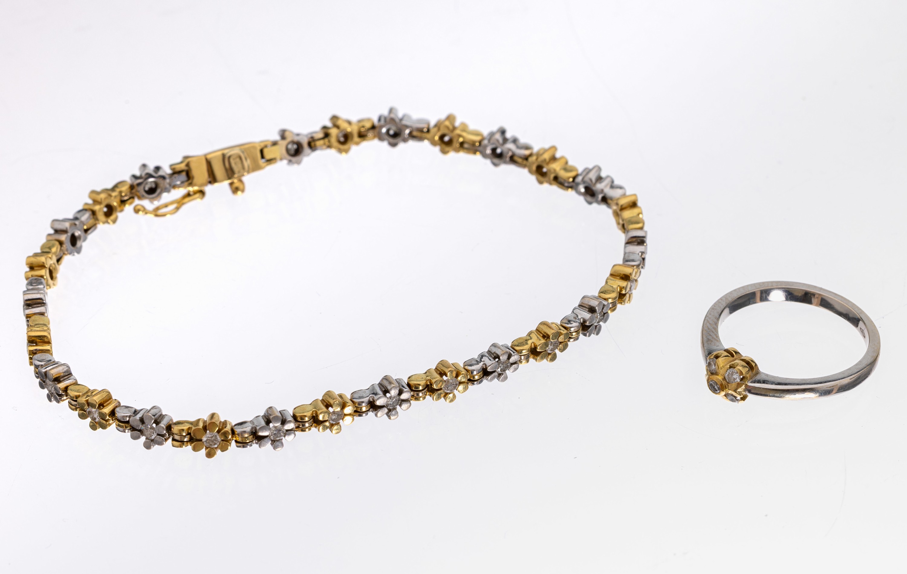 18 kt Gold Brillant-Schmuckset, GG/WG 750/000, best. aus: Armband L. ca. 19 cm, Kastenschloss mit Sicherheitsacht und Ring RW 52, blütenförm. ...
