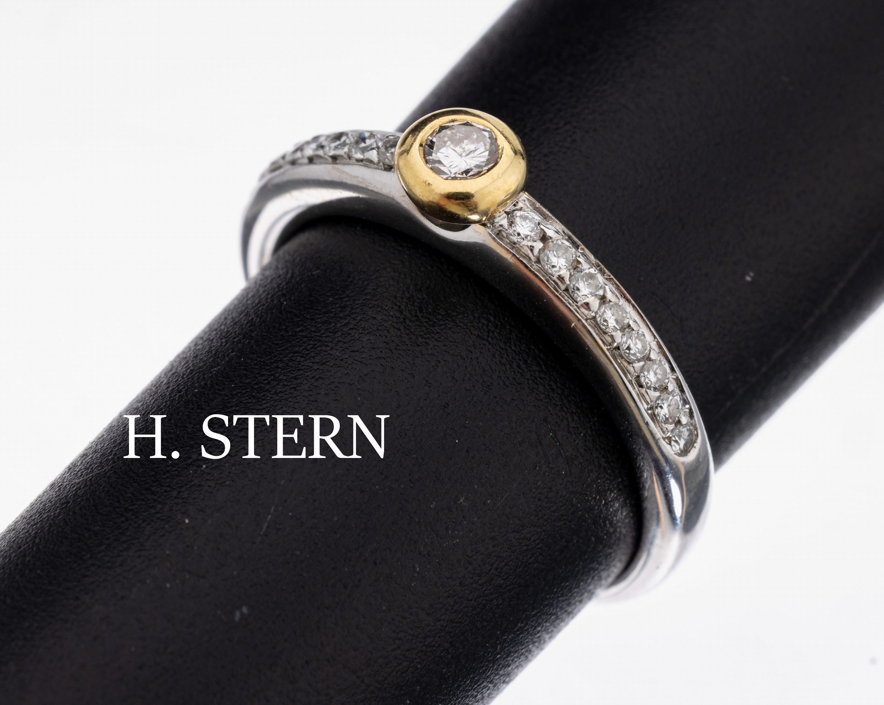 18 kt Gold H. STERN Brillant-Ring, WG/GG 750/000, 1 in GG gefasster Brillant ca. 0.07 ct Weiß/si, Schultern mit 16 Brillanten zus. ca. 0.08 ct ...