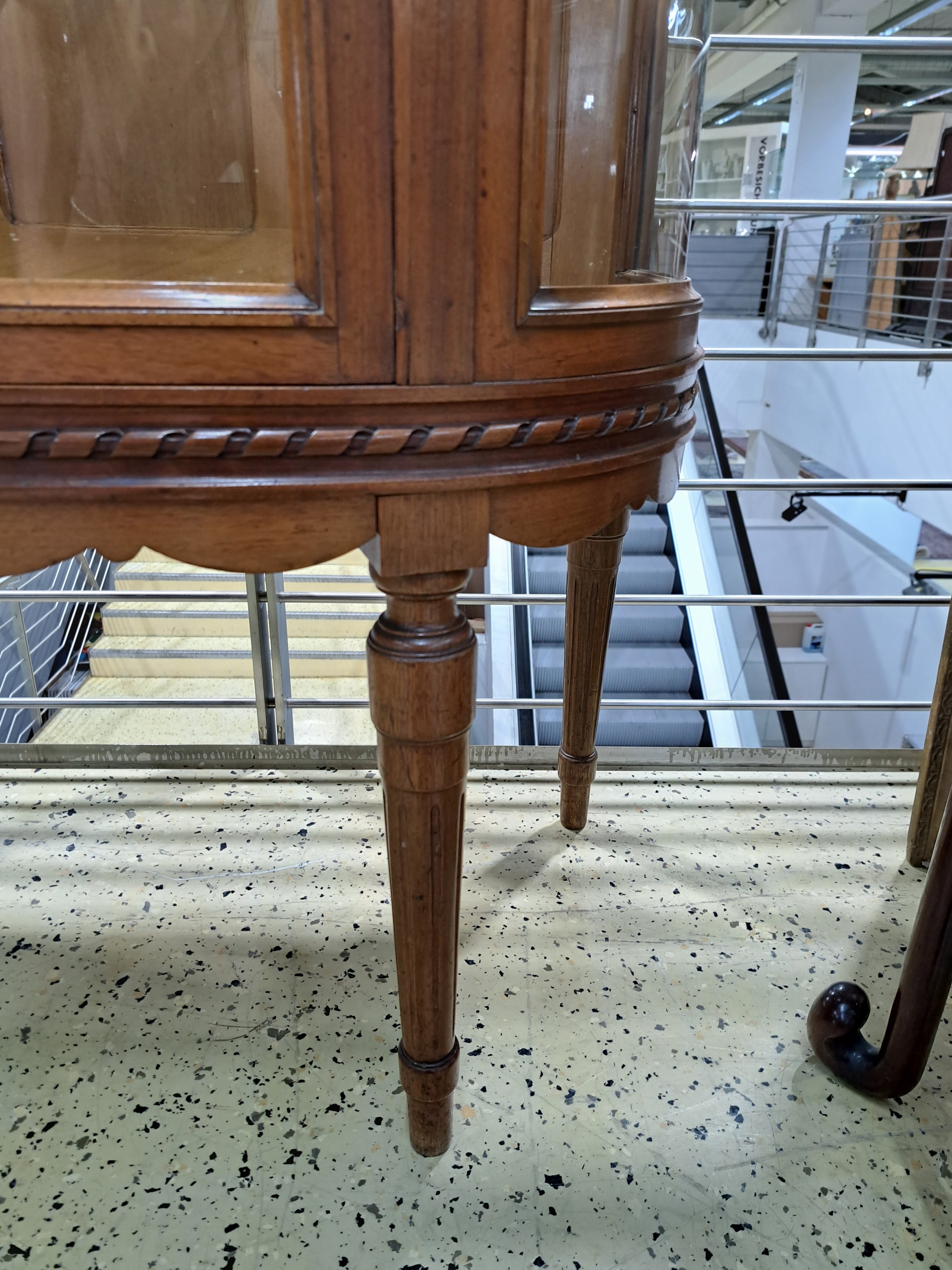Detail g: Vitrine im Stil des Louis-Seize, Frankreich, um 1900, dreiseitig verglast, Korpus im hellen Nußbaum, innen 2 Glasböden, gedrechselte Füße, ca. ...