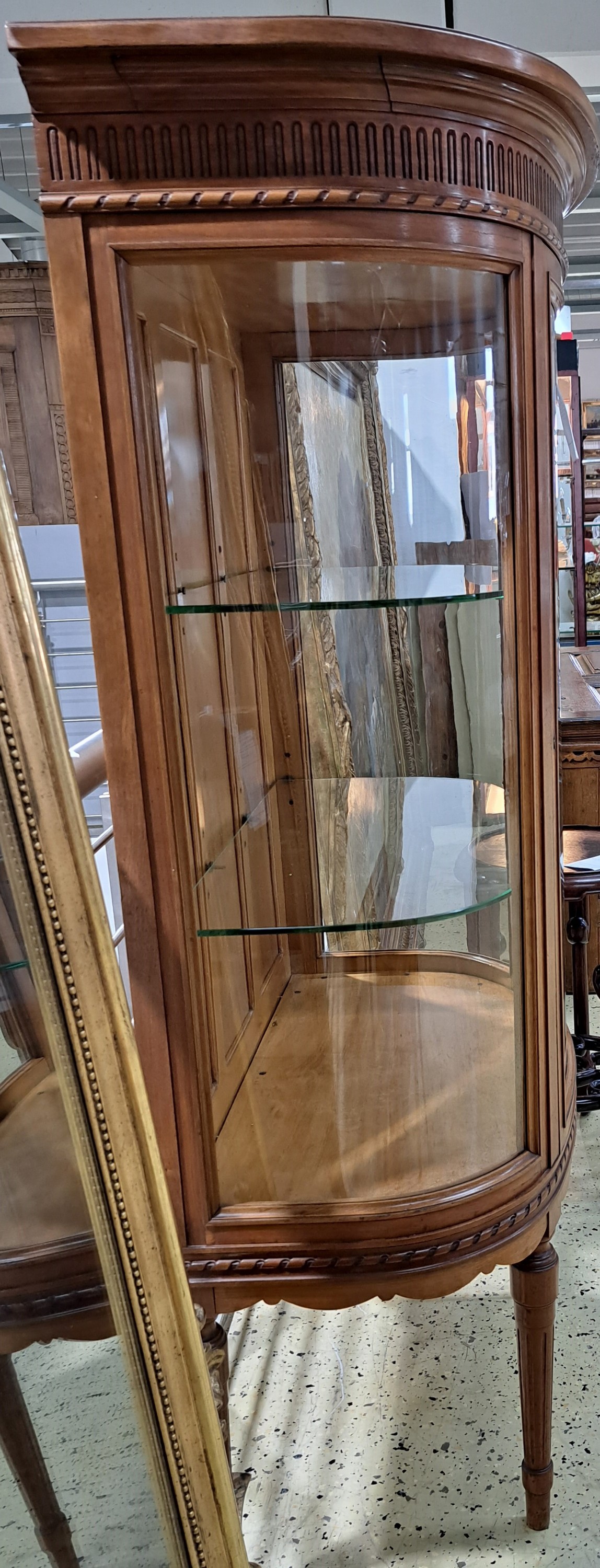 Detail o: Vitrine im Stil des Louis-Seize, Frankreich, um 1900, dreiseitig verglast, Korpus im hellen Nußbaum, innen 2 Glasböden, gedrechselte Füße, ca. ...