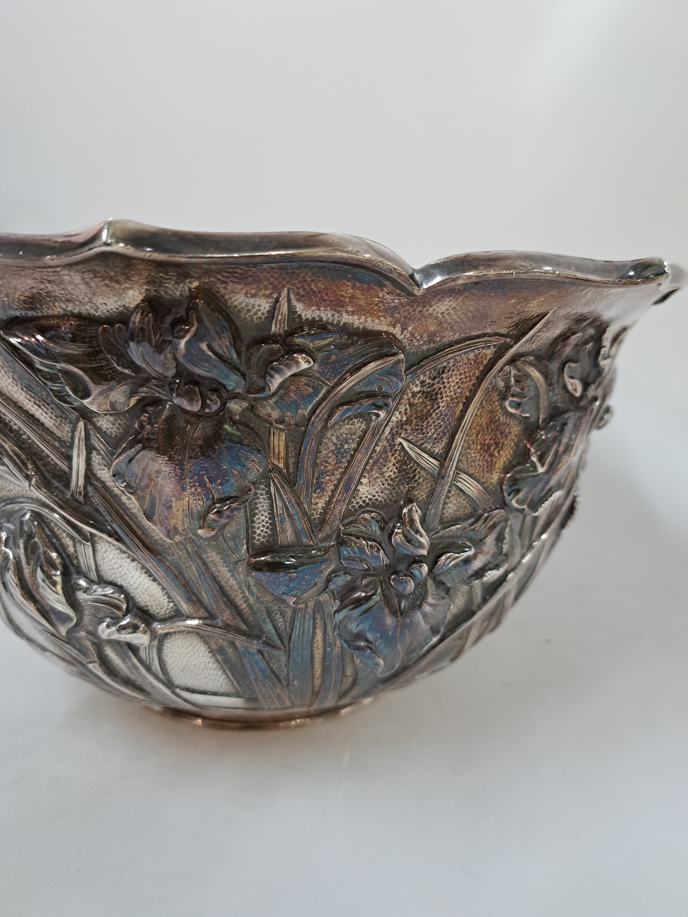 Detail b: Bowle/Blumentopf, China, 20. Jh., Silber, doppelte Wandung, mit umlaufendem, reliefiertem Liliendekor, Rand achtfach geschwungen ausgezogen, am Boden ...