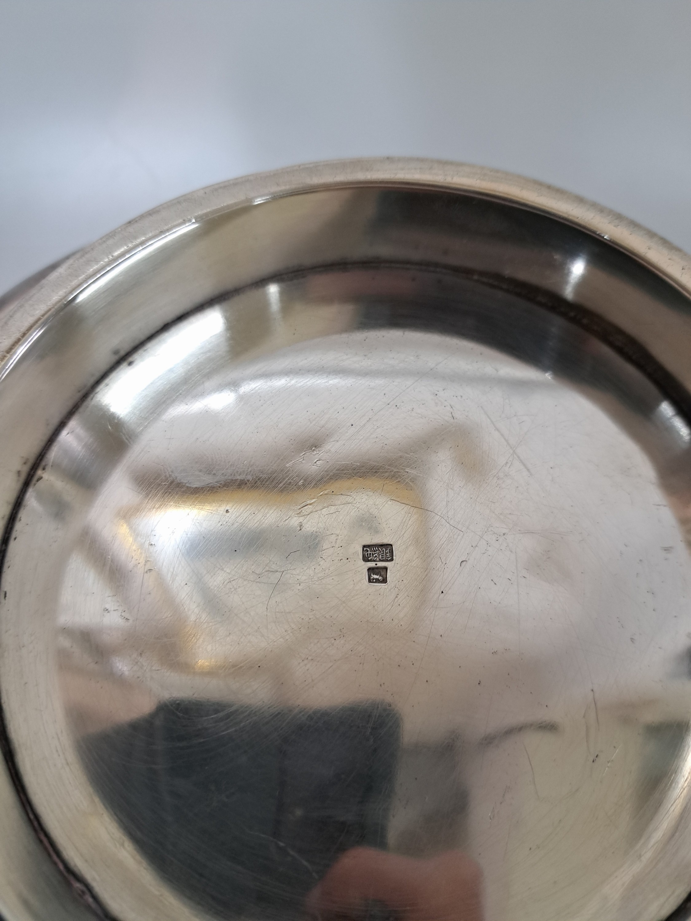 Detail d: Bowle/Blumentopf, China, 20. Jh., Silber, doppelte Wandung, mit umlaufendem, reliefiertem Liliendekor, Rand achtfach geschwungen ausgezogen, am Boden ...