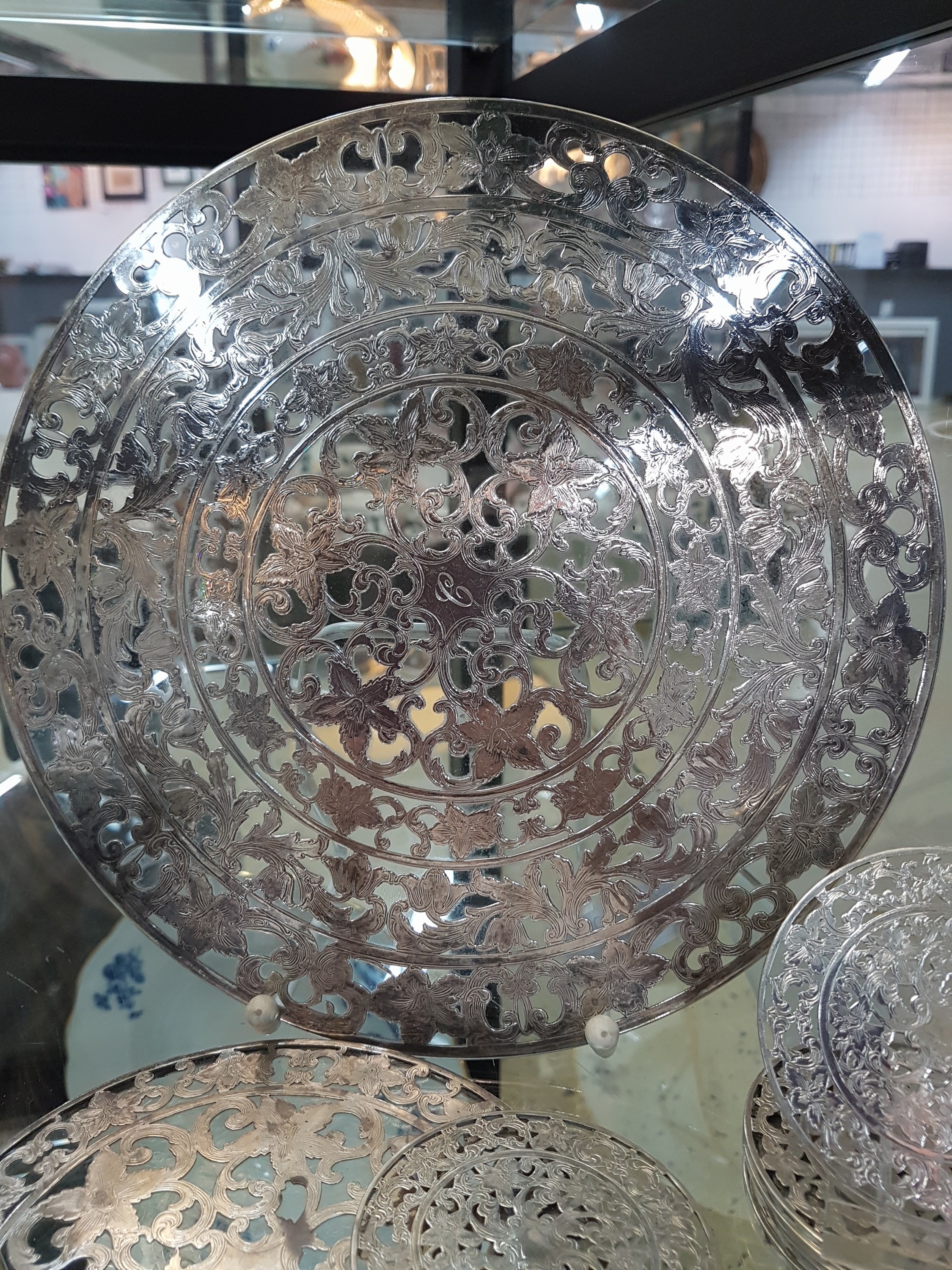 Detail c: Zwei runde Platten und 10 Untersetzer für Gläser, Silveroverlay, Anfang 20. Jh., farbloses Glas, mit floralen Dekoren, Platte gr. D. 25cm, Platte ...