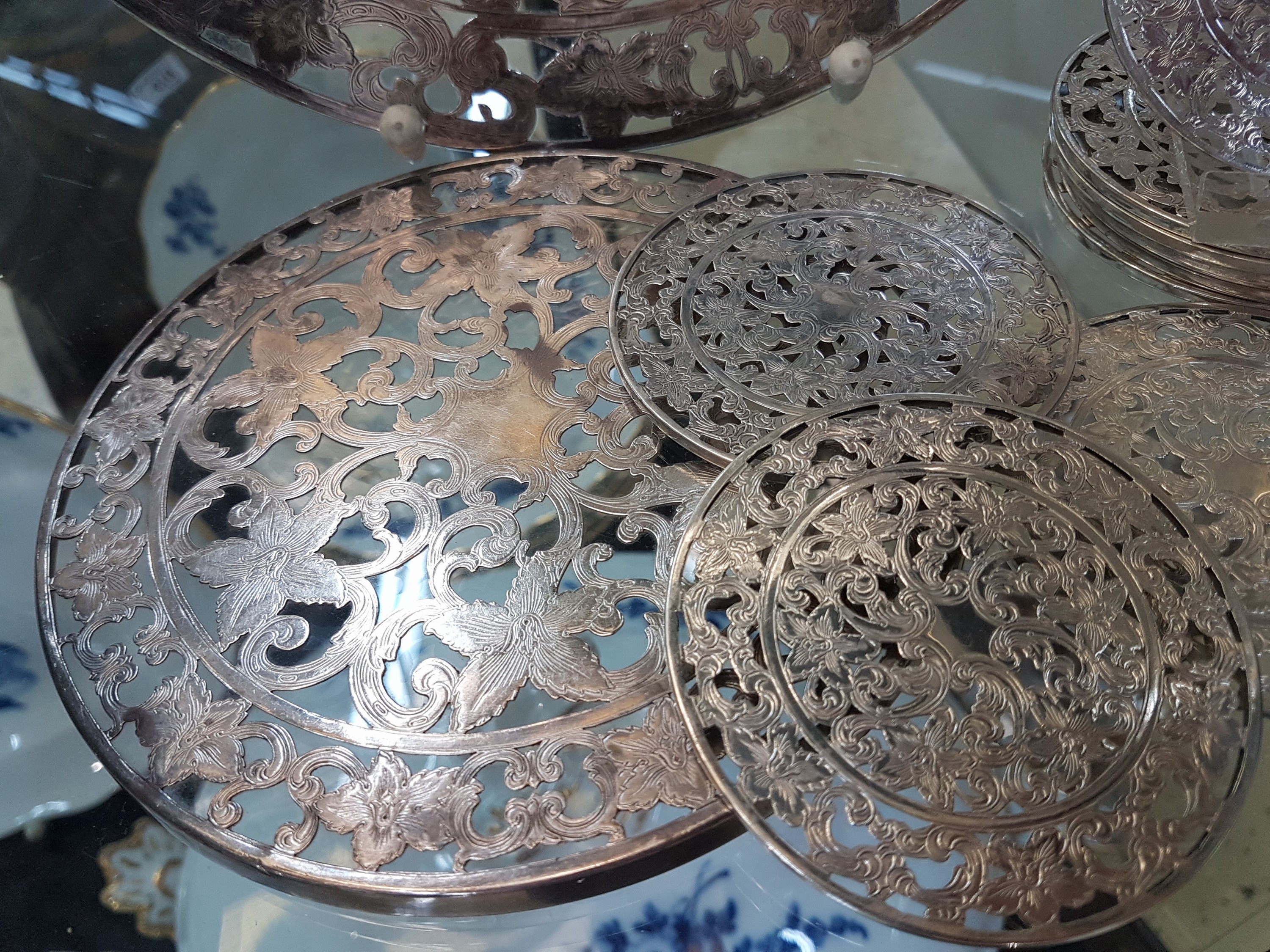 Detail d: Zwei runde Platten und 10 Untersetzer für Gläser, Silveroverlay, Anfang 20. Jh., farbloses Glas, mit floralen Dekoren, Platte gr. D. 25cm, Platte ...