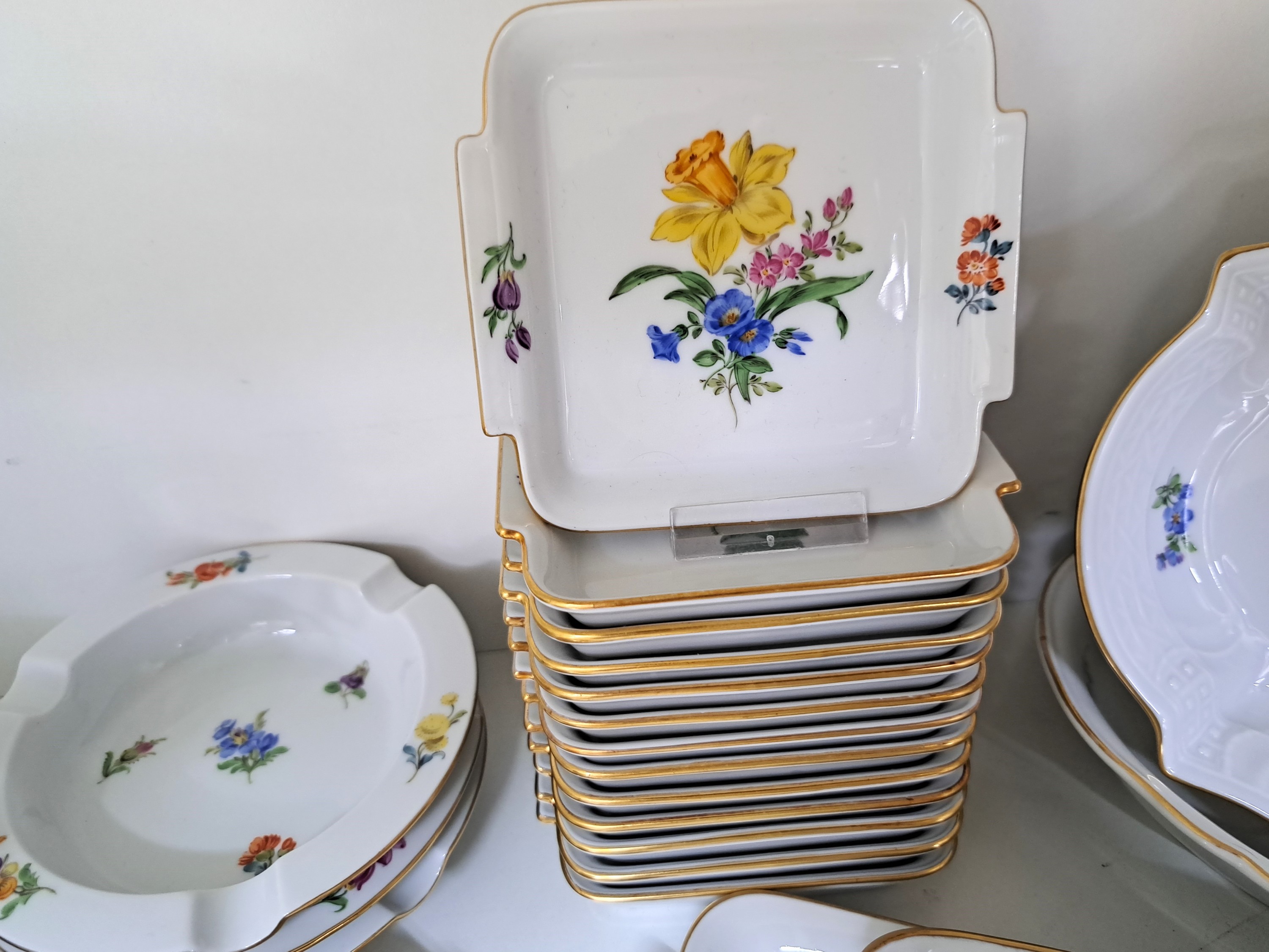 Detail c: 29 Platten und Schalen, Meissen, 20. Jh., Porzellan, alle mit Blumenmalerei, u.a. 12 rechteckige Schälchen, Kuchenplatte L. 29 cm, rechteckige ...