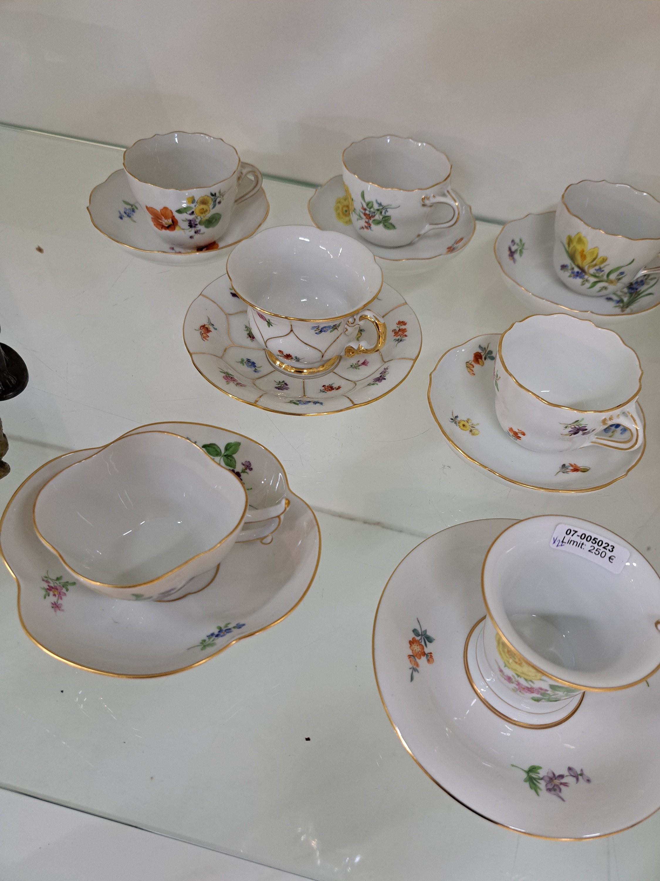 Detail b: 10 Mokkatassen, Meissen, 20. Jh., verschiedene Dekore,u.a. B-Form, Vierpass, Neuer Ausschnitt, Blumenbemalungen, z.T. 2. Wahl, Goldränder