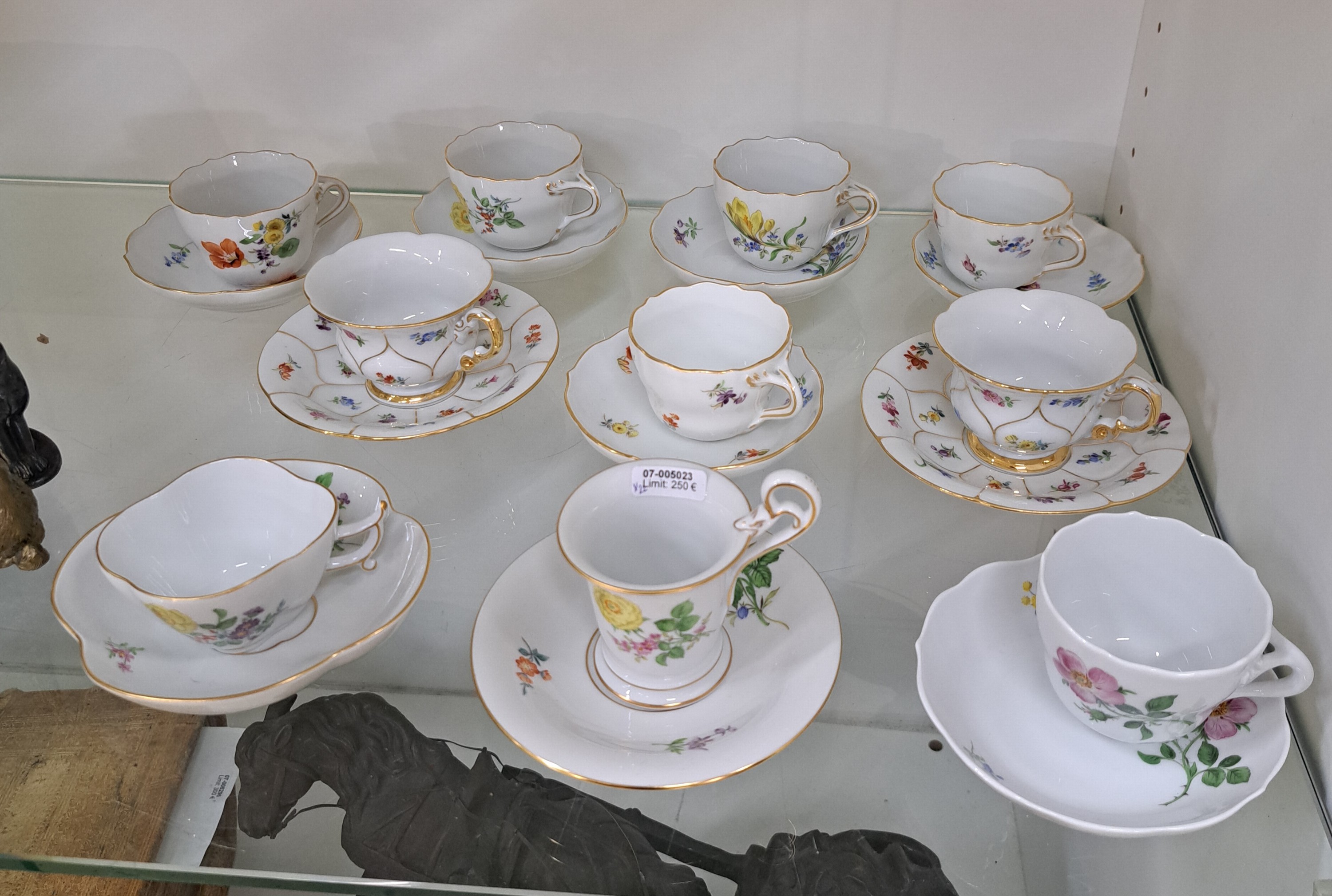 Detail e: 10 Mokkatassen, Meissen, 20. Jh., verschiedene Dekore,u.a. B-Form, Vierpass, Neuer Ausschnitt, Blumenbemalungen, z.T. 2. Wahl, Goldränder