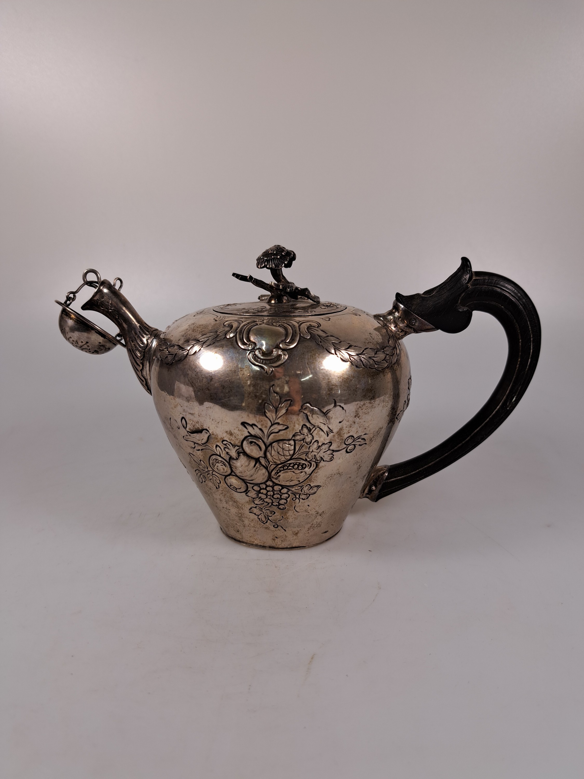 Detail a: Teekanne aus Silber, 19.Jh., Silber, reliefiert mit Blumen und Girlanden, Griff ebonisiertes Holz, eingestecktes Teesieb, H. ca. 13cm, Marken ...