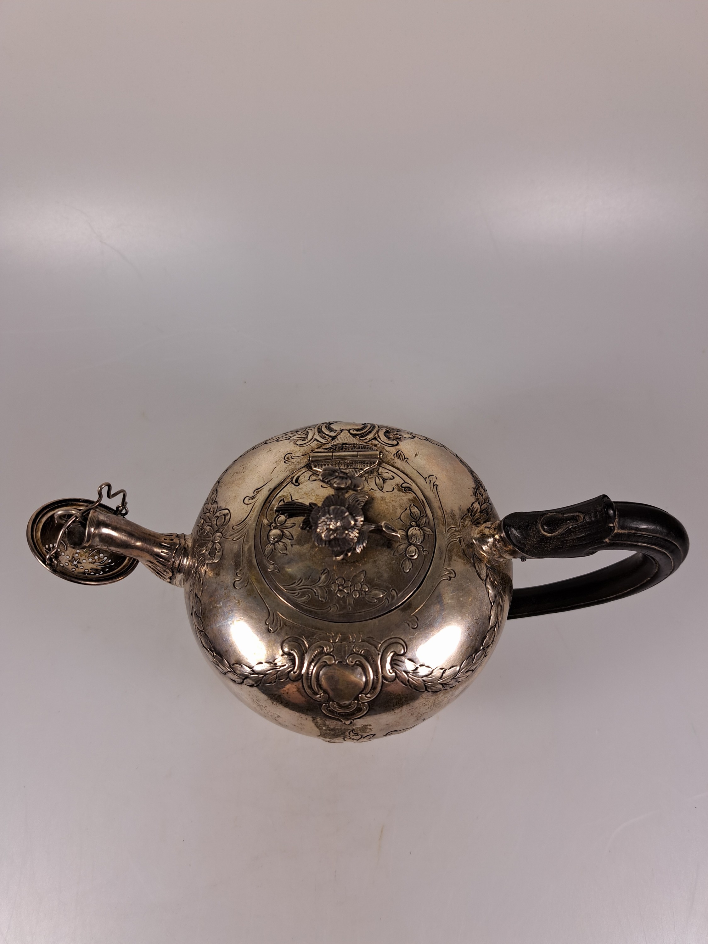 Detail b: Teekanne aus Silber, 19.Jh., Silber, reliefiert mit Blumen und Girlanden, Griff ebonisiertes Holz, eingestecktes Teesieb, H. ca. 13cm, Marken ...