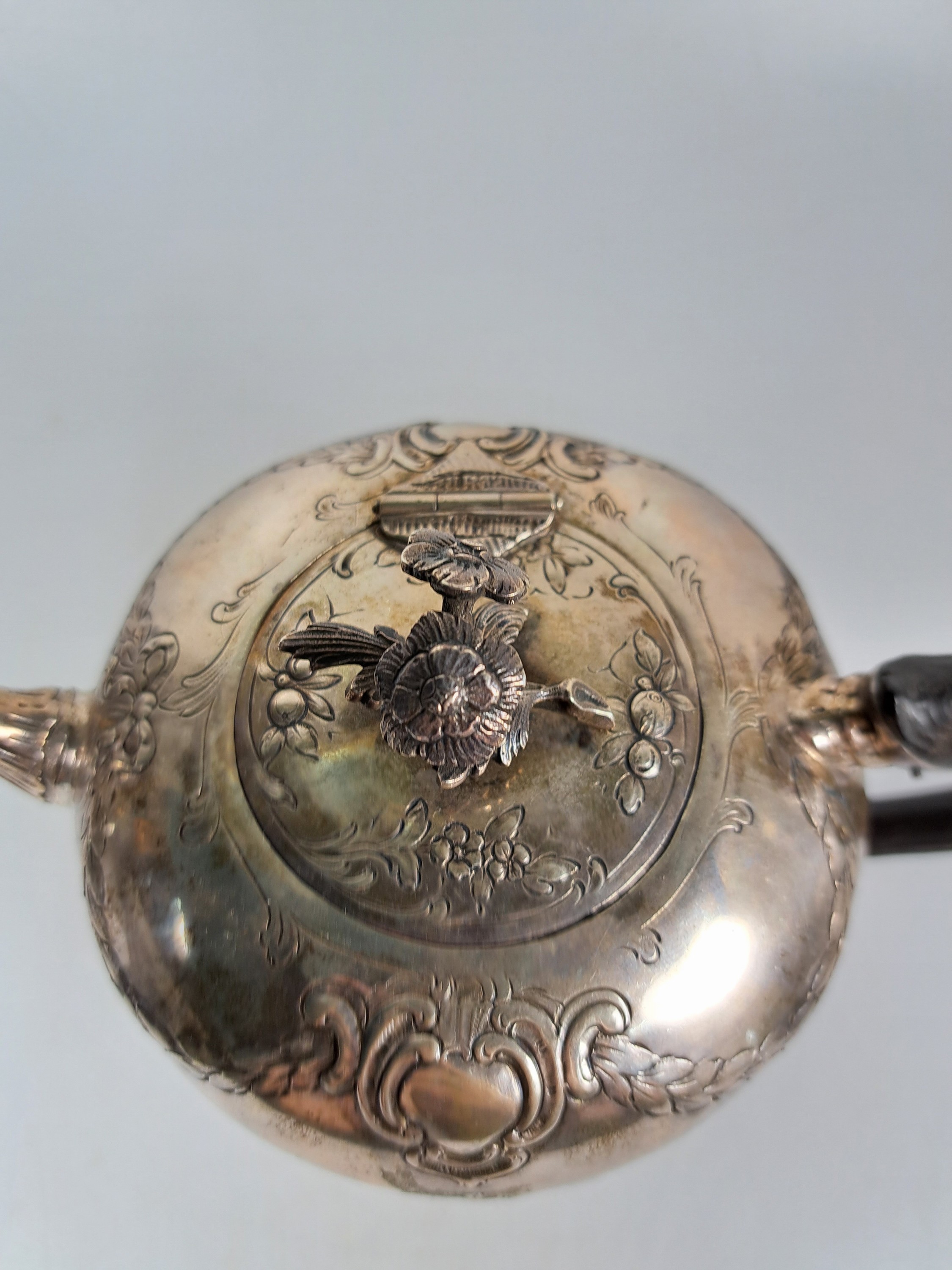 Detail c: Teekanne aus Silber, 19.Jh., Silber, reliefiert mit Blumen und Girlanden, Griff ebonisiertes Holz, eingestecktes Teesieb, H. ca. 13cm, Marken ...