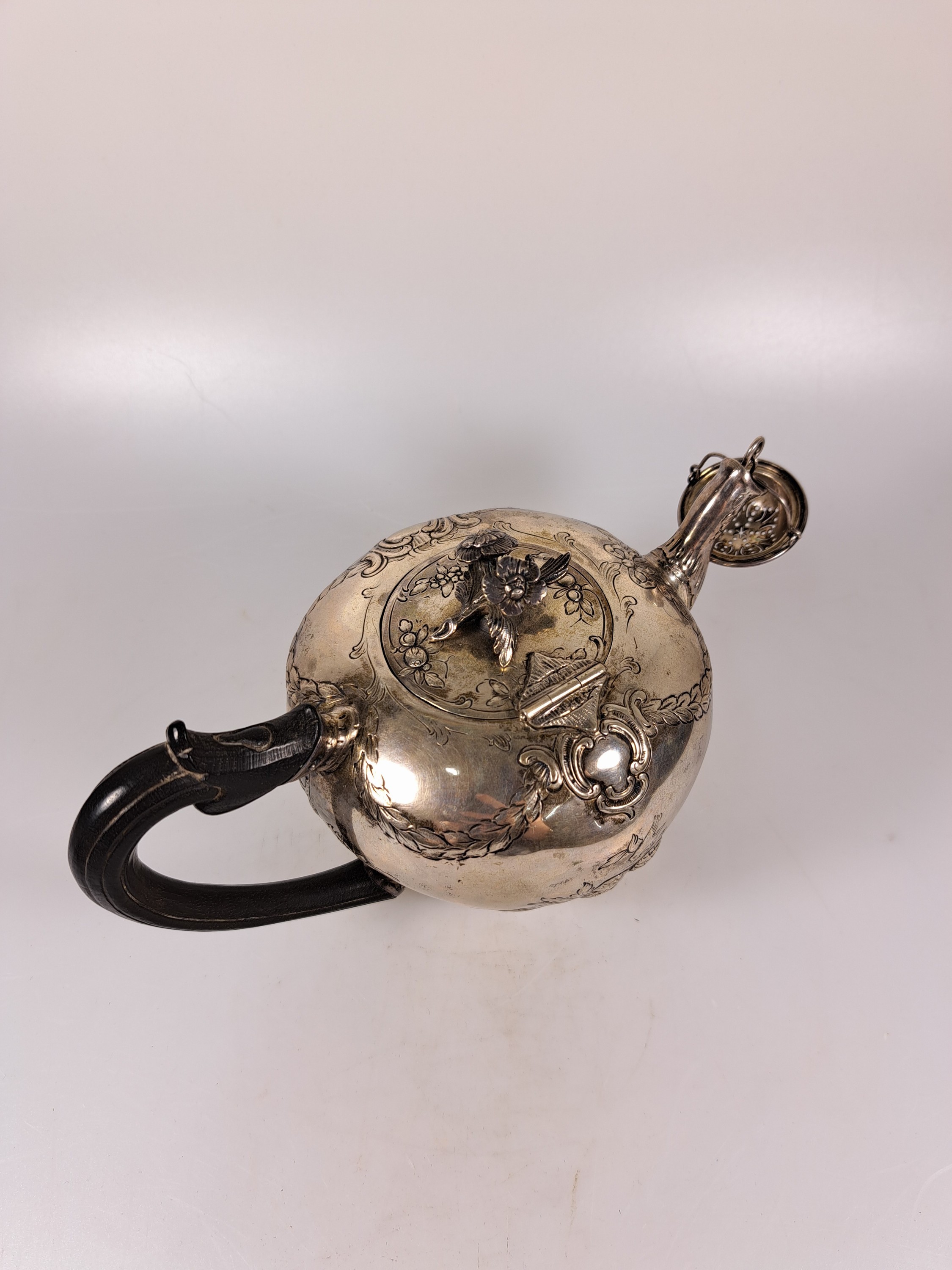 Detail f: Teekanne aus Silber, 19.Jh., Silber, reliefiert mit Blumen und Girlanden, Griff ebonisiertes Holz, eingestecktes Teesieb, H. ca. 13cm, Marken ...