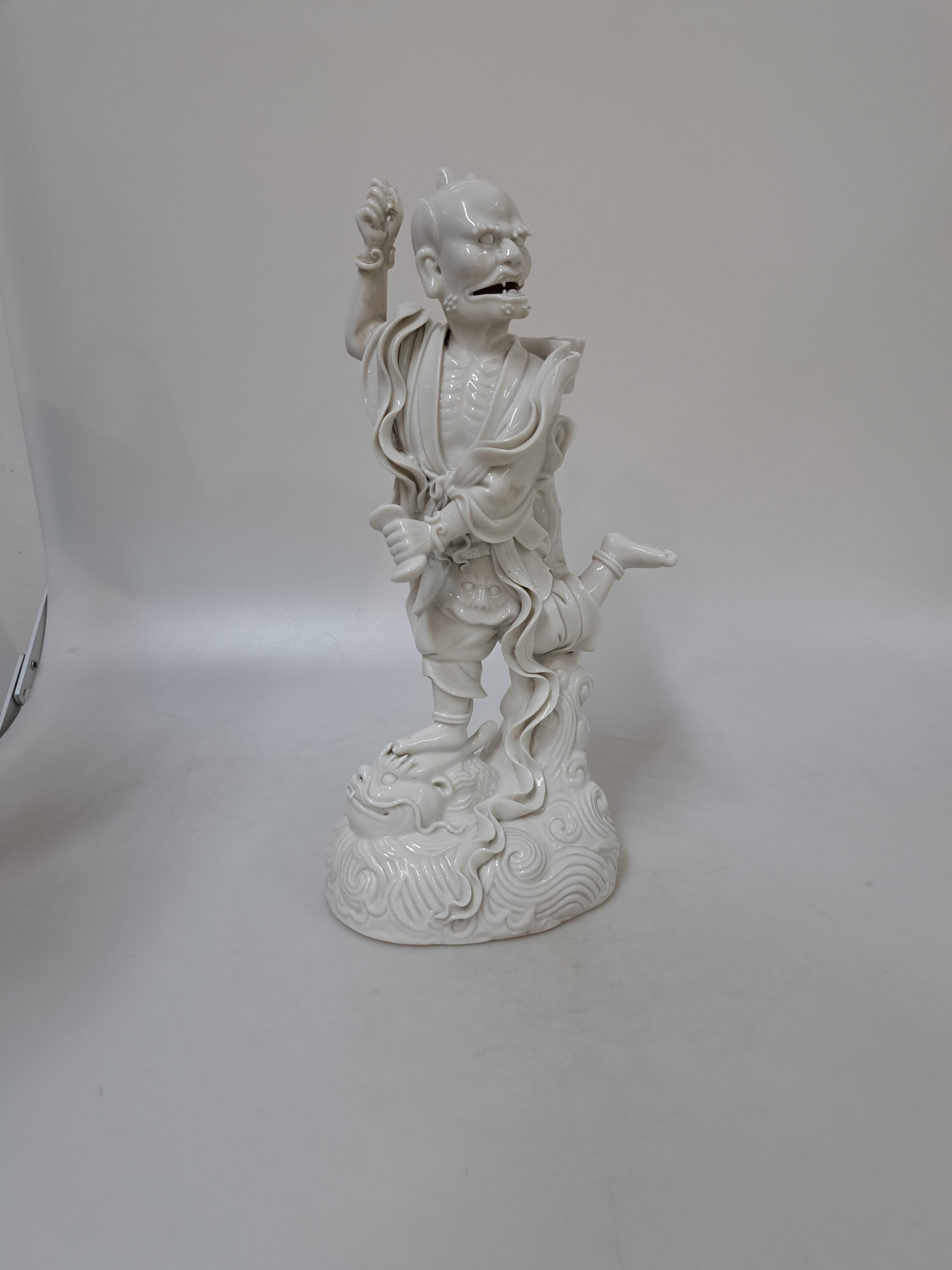 Detail b: Porzellanfigur, China, um 1900, sog. blanc-de-blanc, Darstellung eines Dämon, auf einem Drachenkopf stehend, H. ca. 27cm